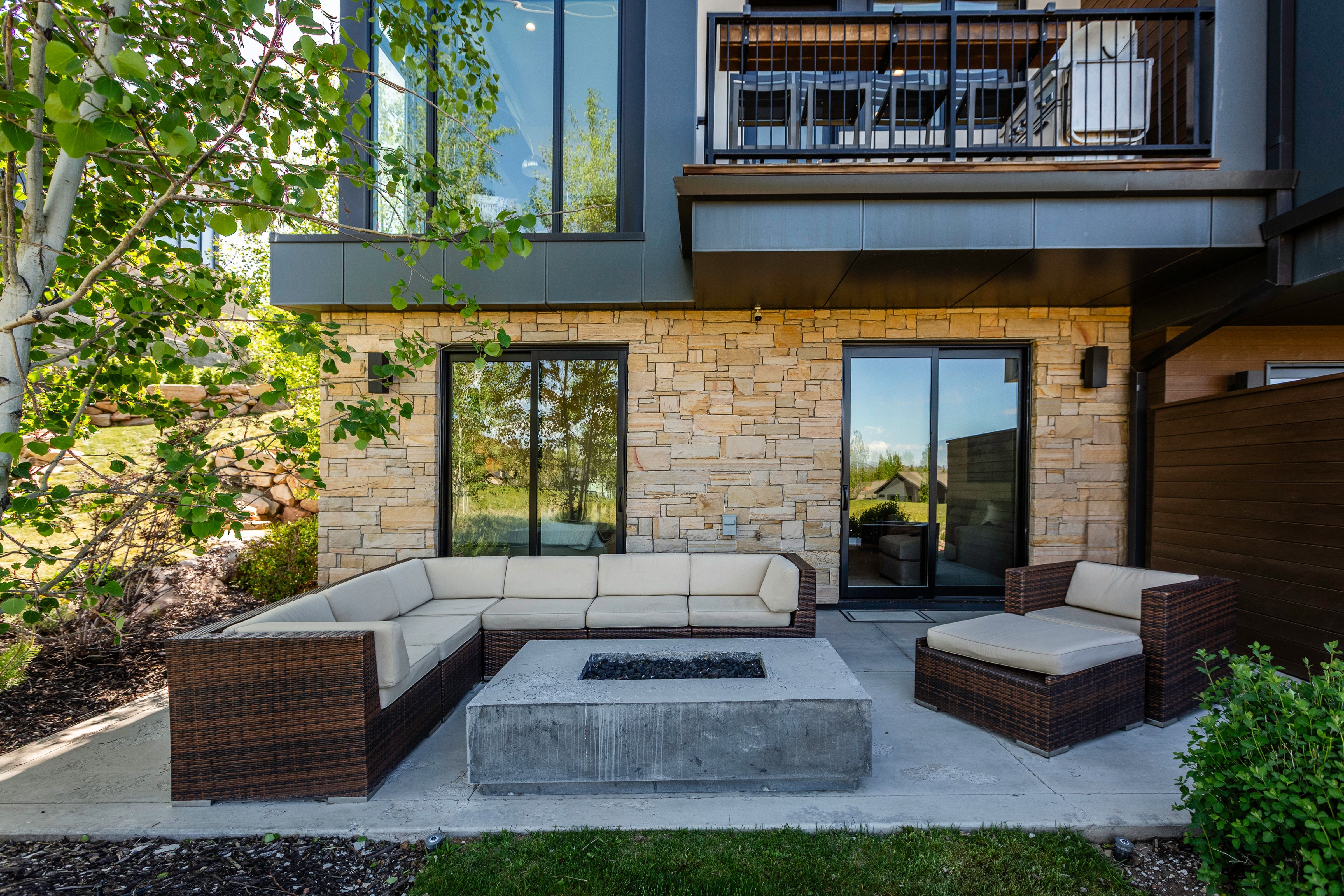 Outdoor patio with a concrete surface, featuring a built-in concrete fire pit