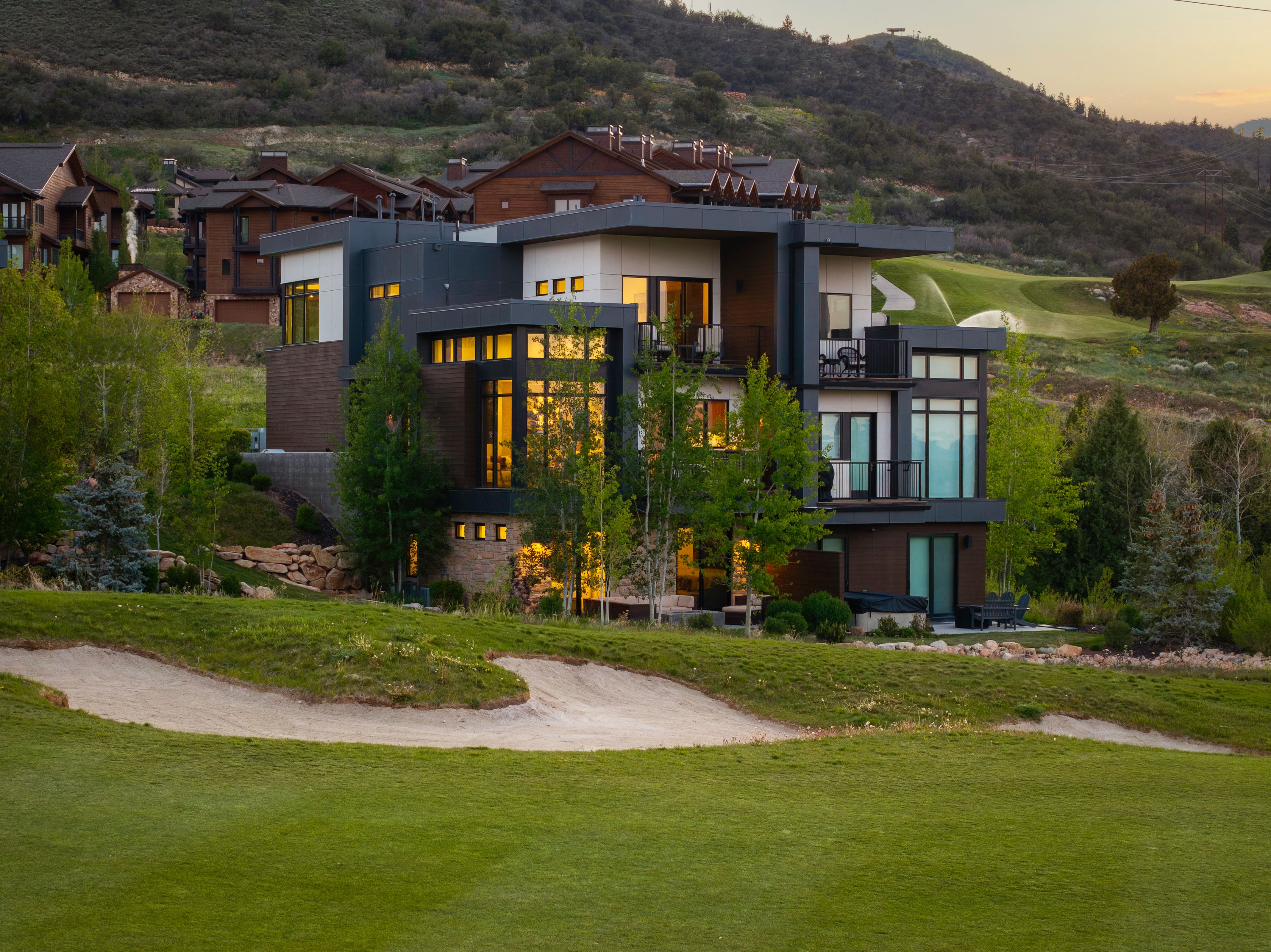Contemporary architectural design featuring expansive window walls, multiple balconies, and a multi-level structure