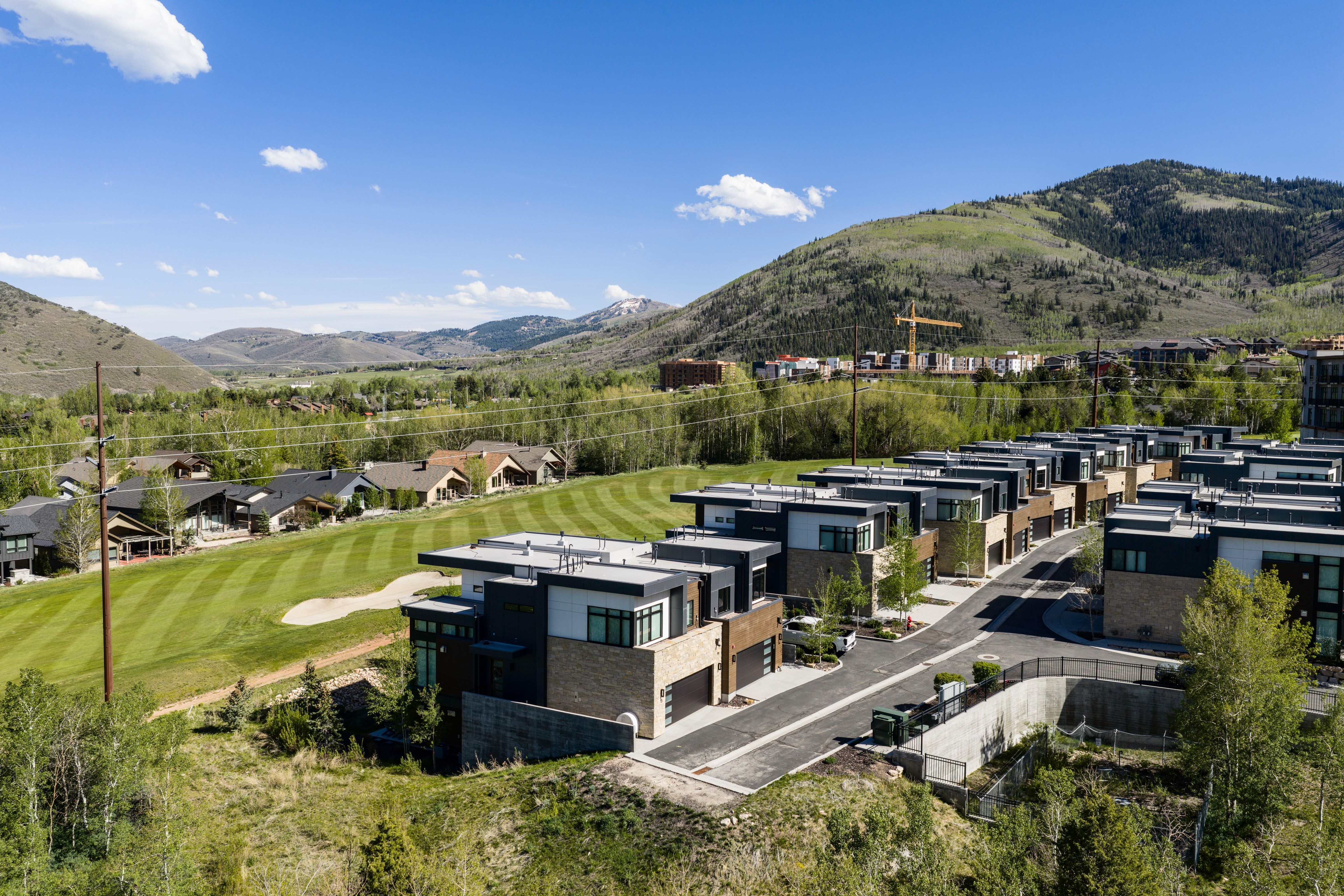 Modern townhome community featuring contemporary architecture, multiple garages, and a paved private road