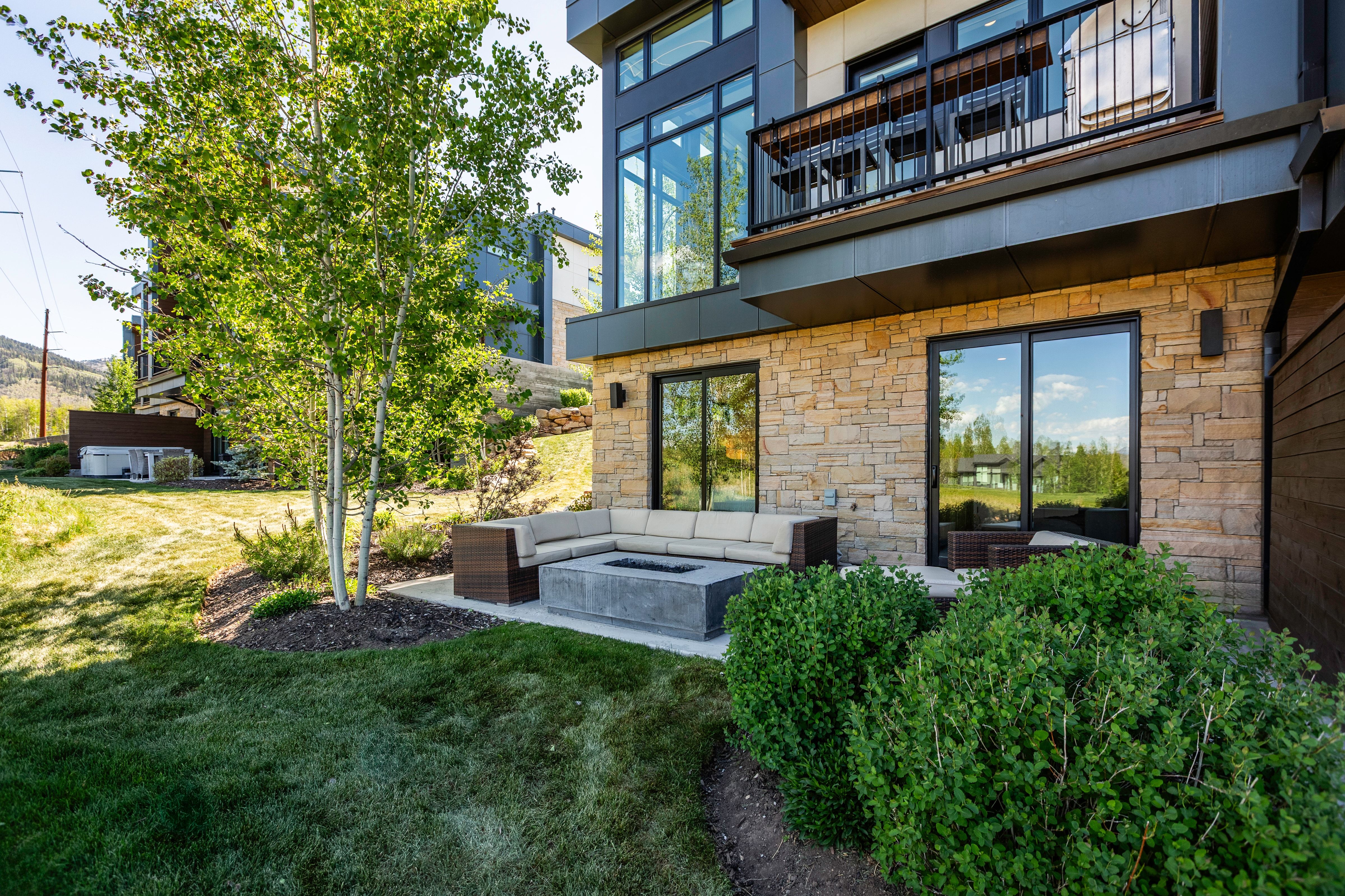 Stone-clad exterior featuring a ground-level patio with a built-in fire pit