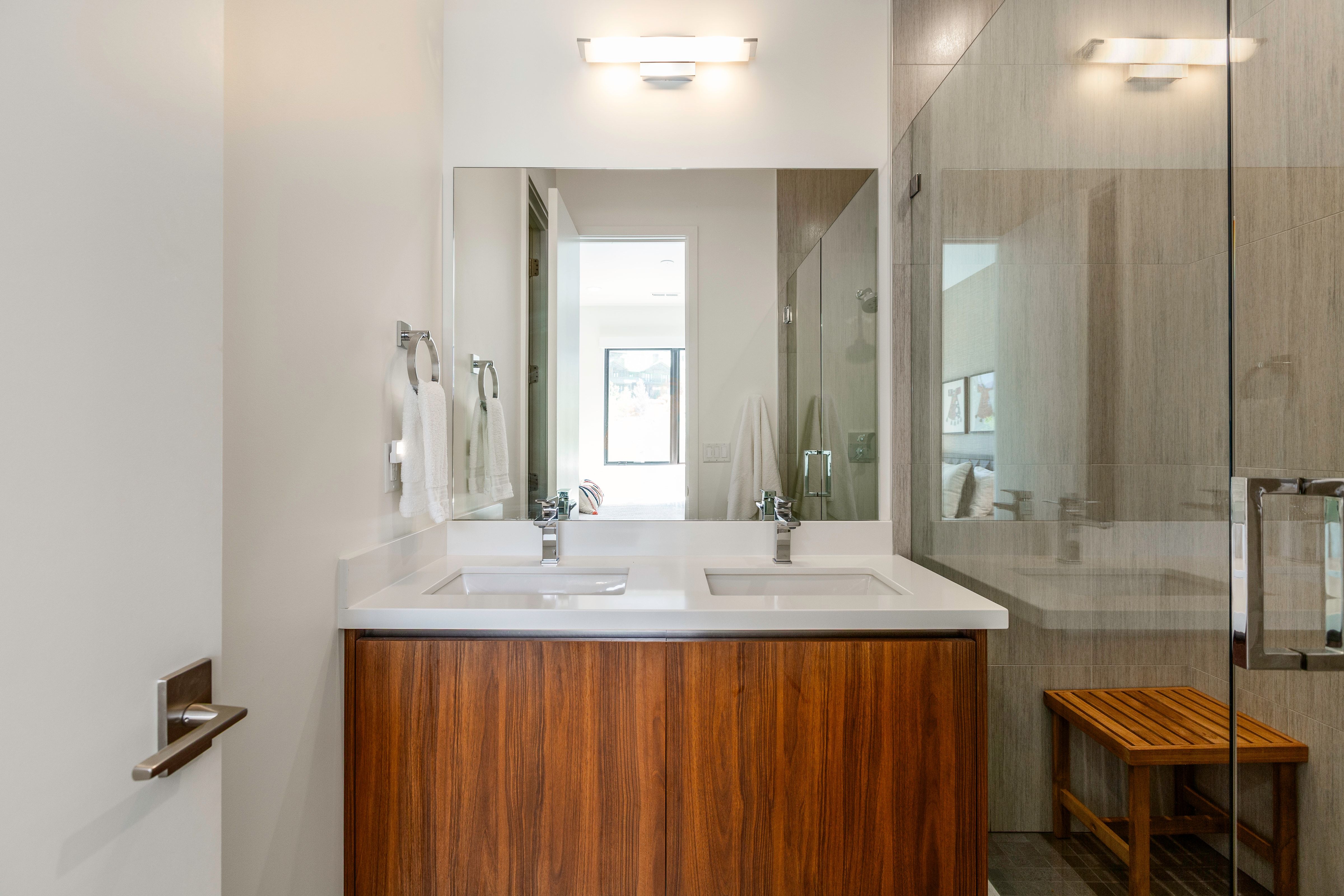Dual vanity with a wood-finish cabinet, white countertop, and integrated sinks