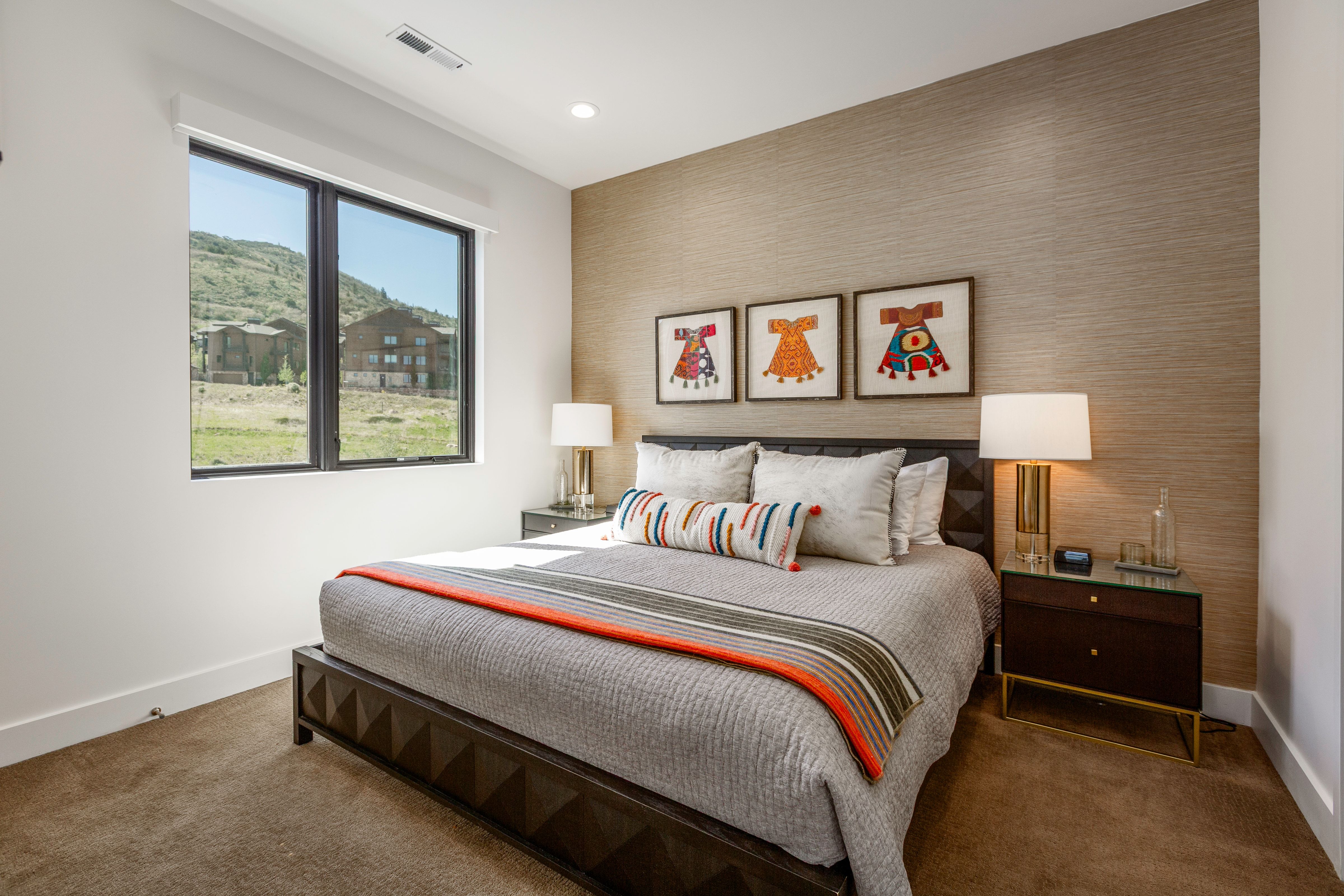Bedroom featuring a large multi-pane window, textured accent wall, recessed lighting, and integrated ceiling vent