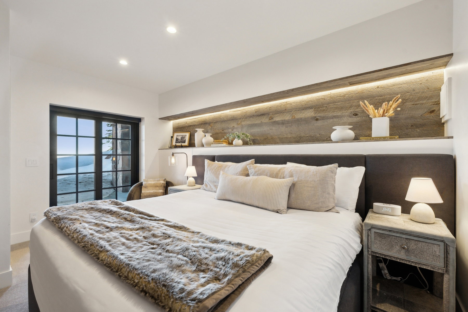 Bedroom featuring a built-in wood-paneled accent wall with integrated ambient lighting and a display shelf