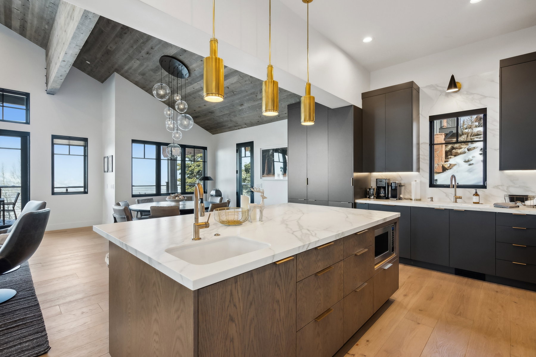 Contemporary kitchen featuring an oversized island with an integrated sink and microwave drawer