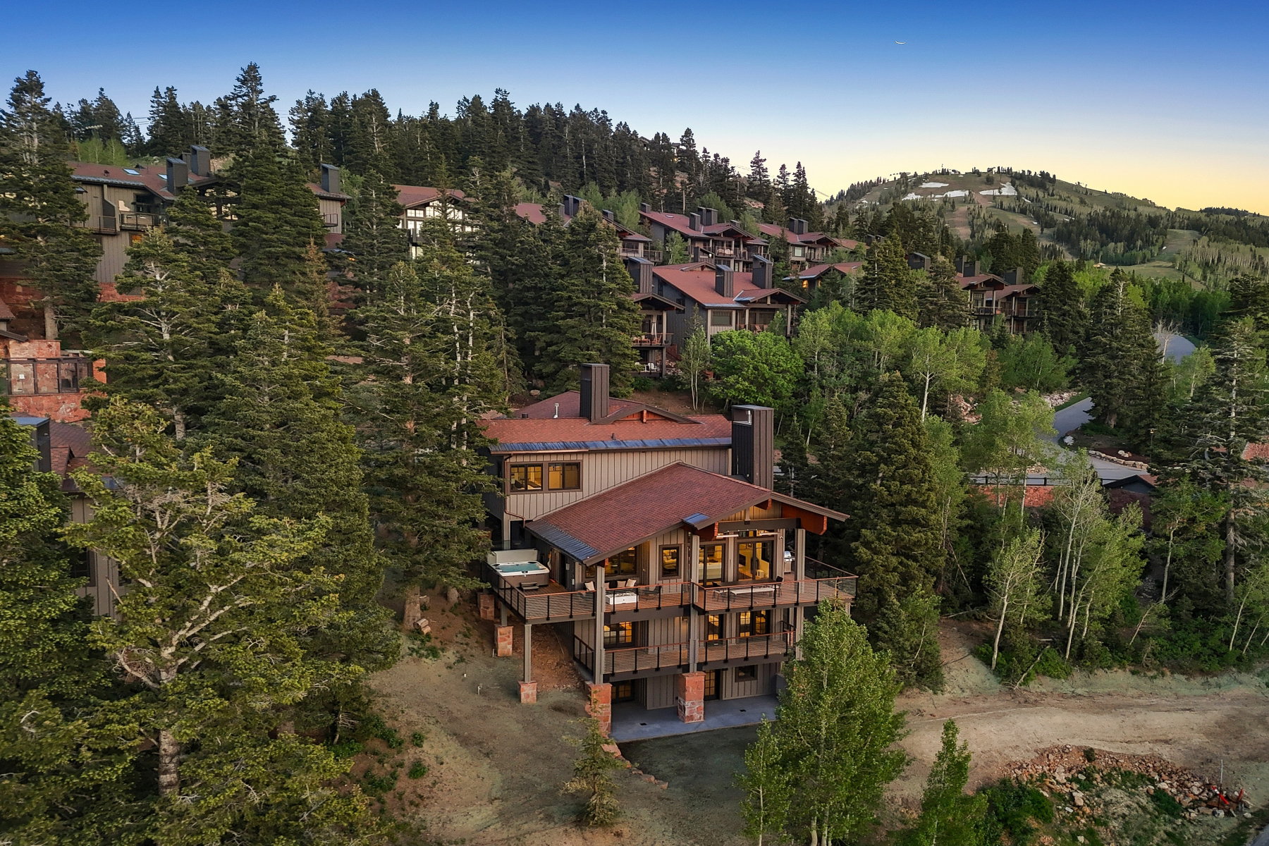 Multi-level mountain home featuring a natural wood siding facade and red tile roofing