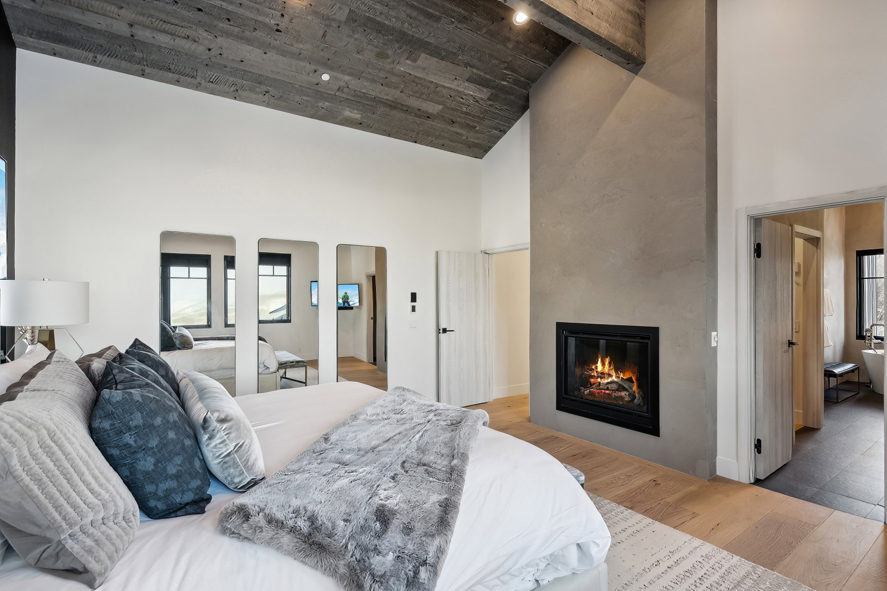 Wood-finish flooring with a gas fireplace featuring a stone-finish hearth and surround