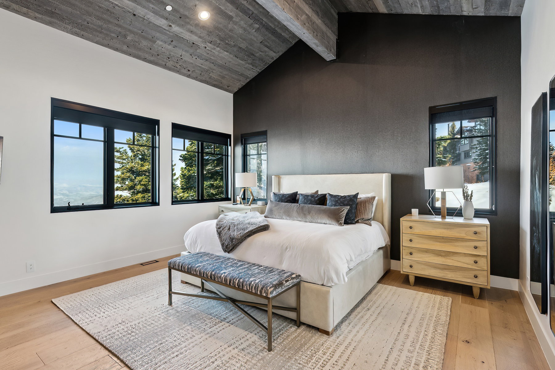 Vaulted wood-paneled ceiling accentuates this bedroom with light wood-finish flooring