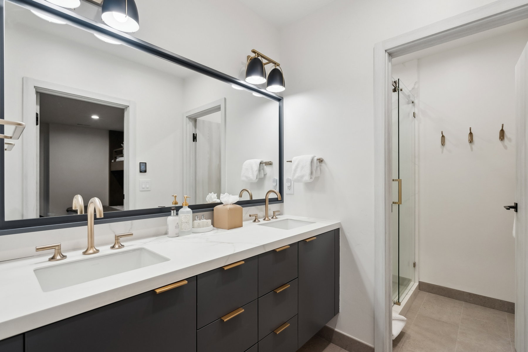 Dual vanity with quartz countertop, undermount sinks, and brushed gold fixtures