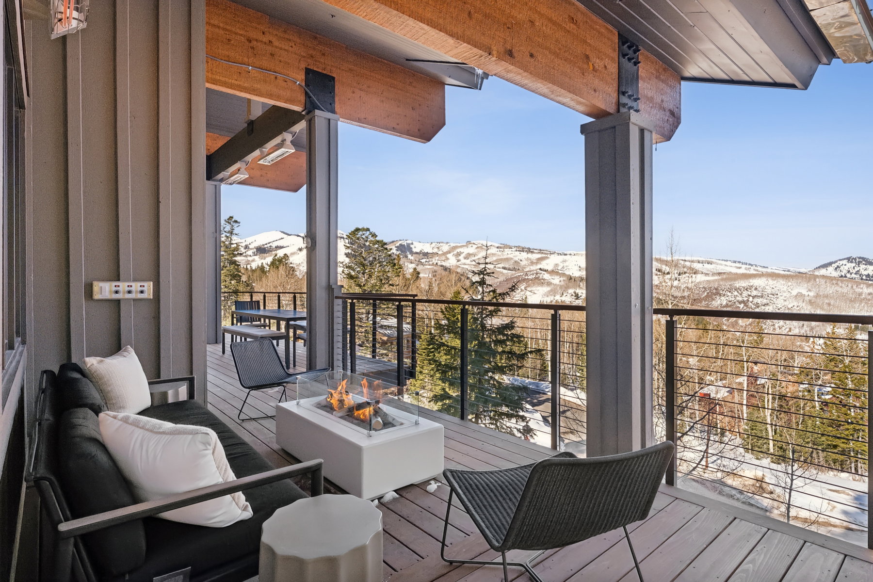 Expansive outdoor deck featuring wood-finish flooring, a cable railing system, and robust structural beams