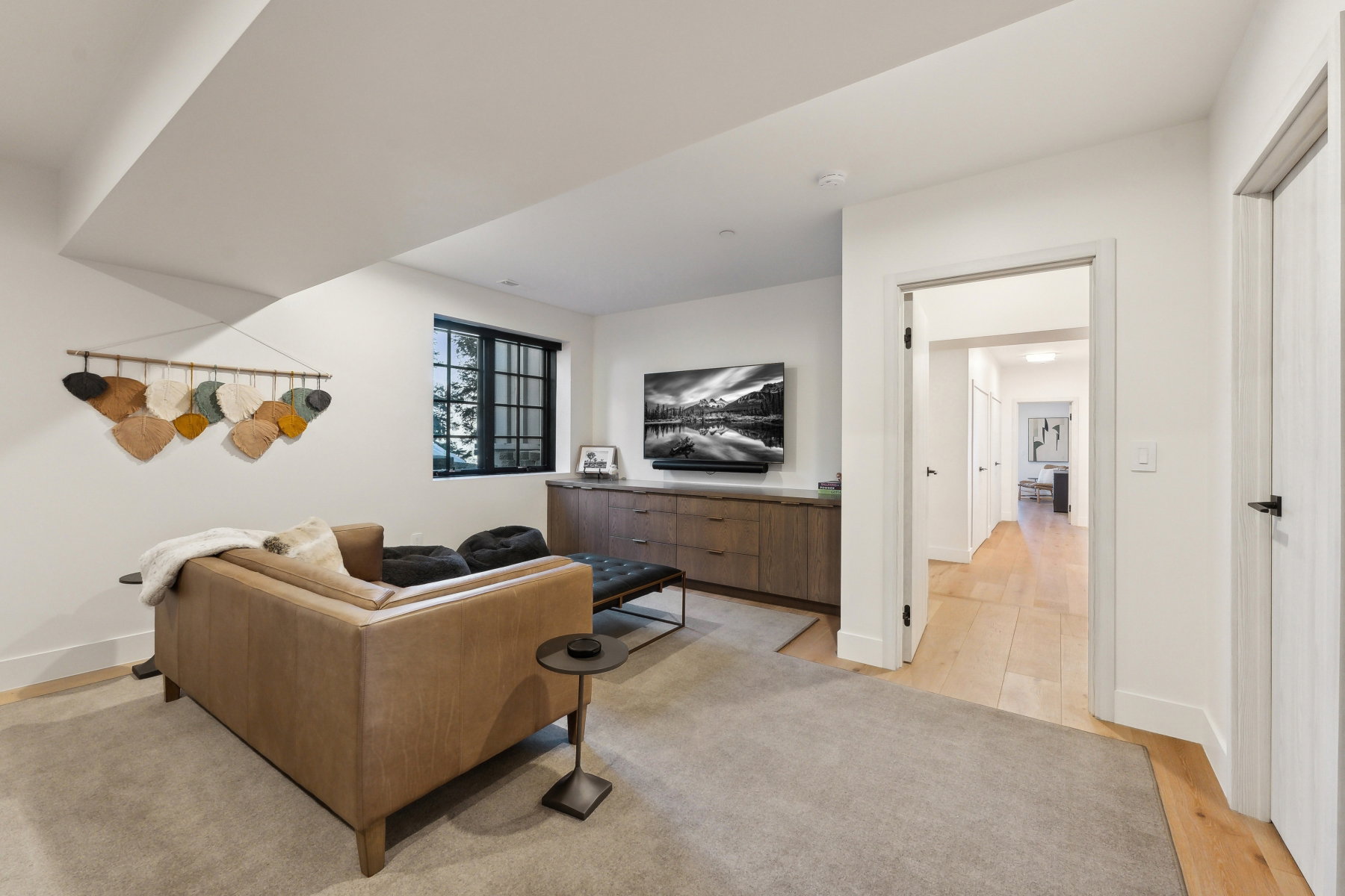 Recessed lighting highlights a window with black muntins