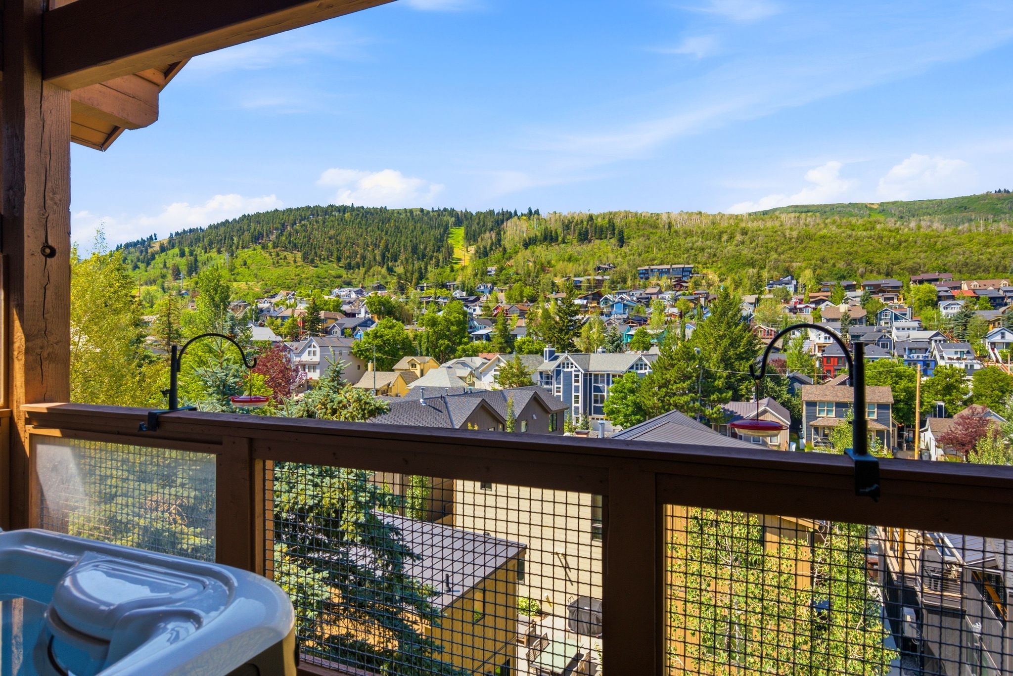 Covered deck featuring a hot tub and views of Old Town and Park City Resort