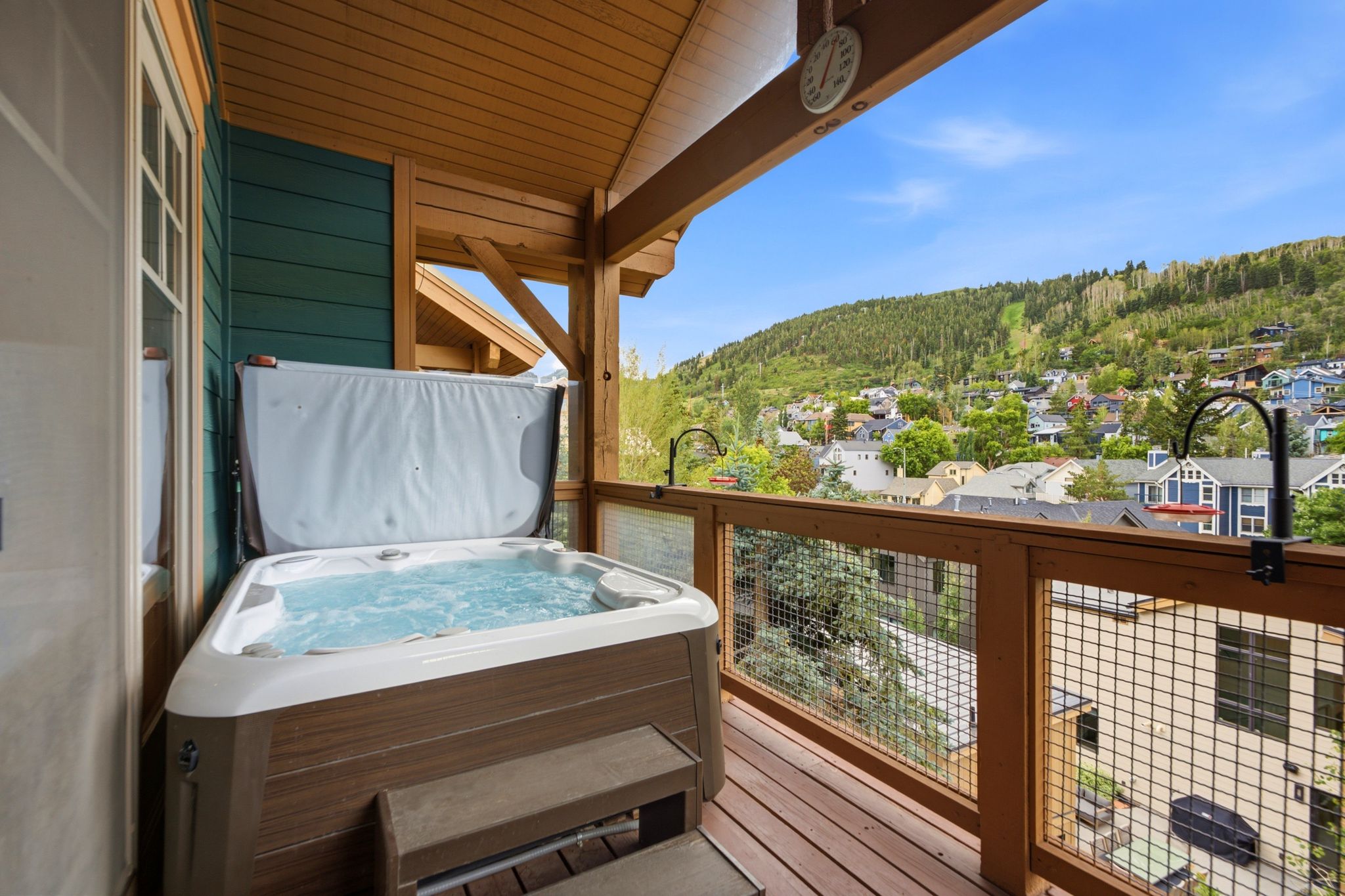 Covered deck featuring a hot tub and views of Old Town and Park City Resort