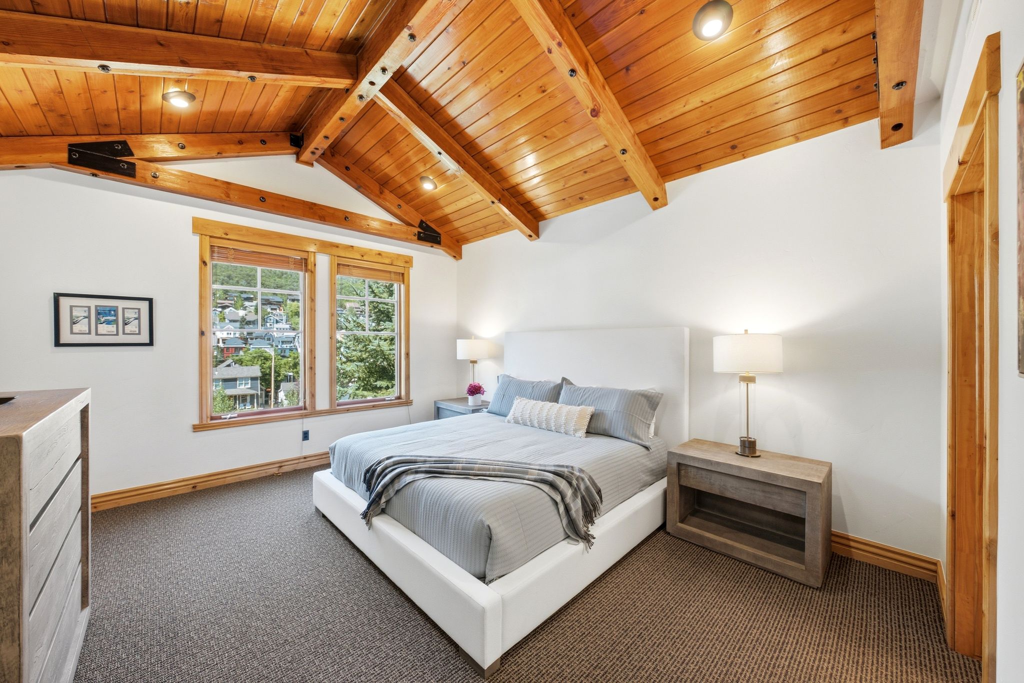 Spacious Primary Bedroom Suite, vaulted wood-paneled ceiling with exposed beams, and Old Town Park City views