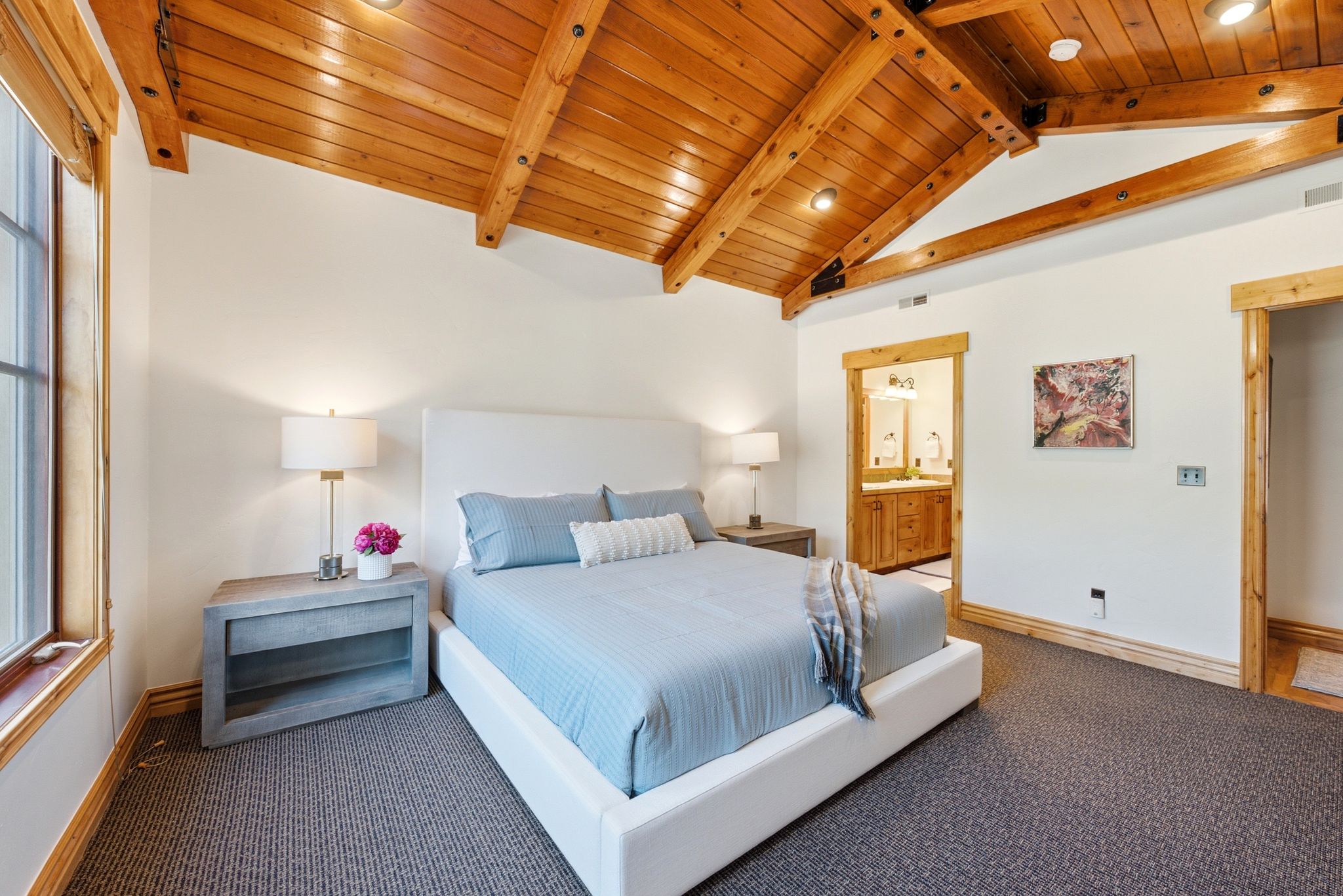 Spacious Primary Bedroom Suite, vaulted wood-paneled ceiling with exposed beams, and Old Town Park City views