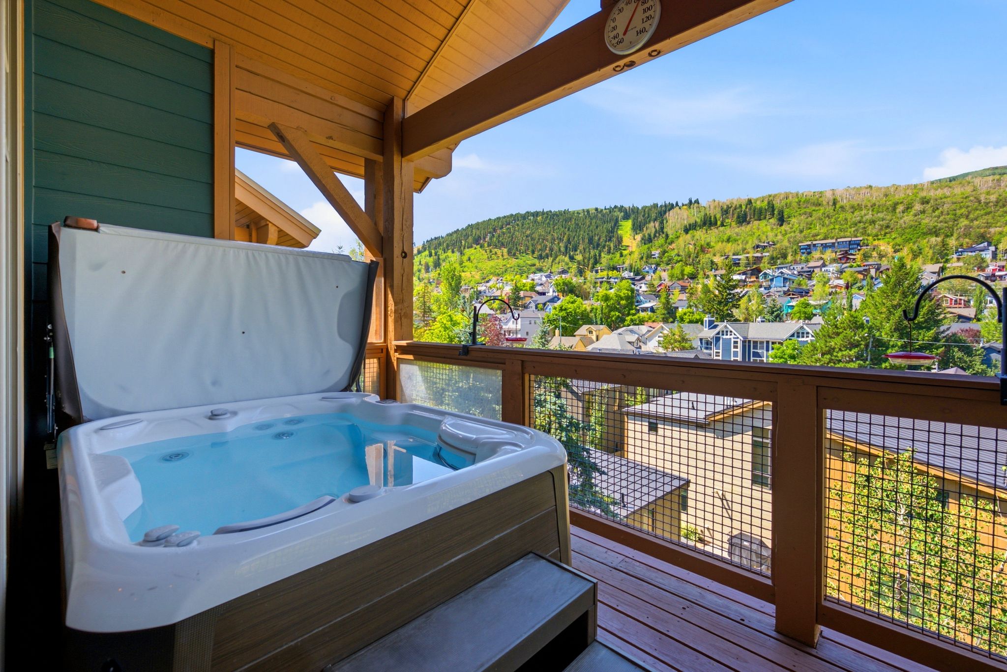 Covered deck featuring a hot tub and views of Old Town and Park City Resort