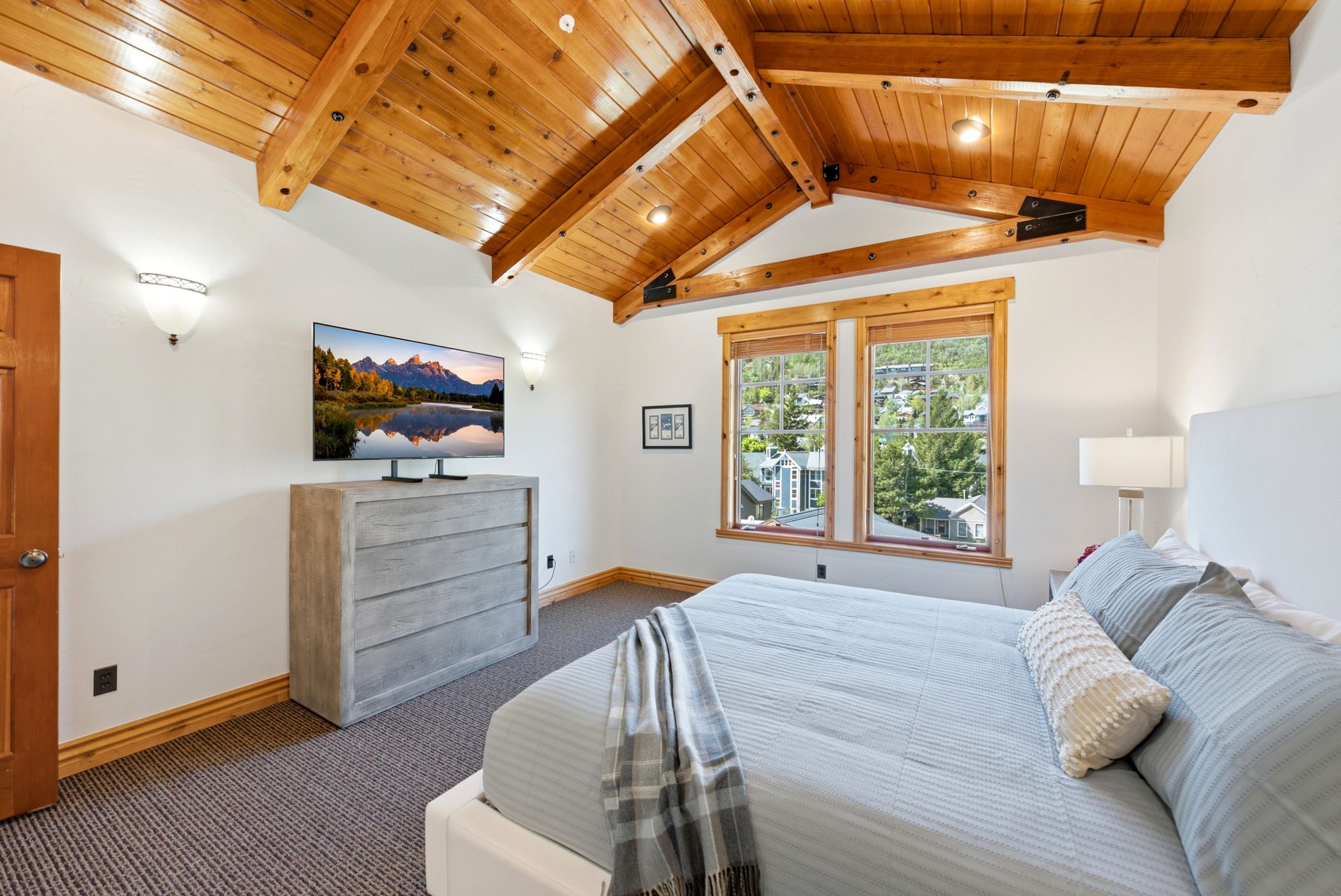 Spacious Primary Bedroom Suite, vaulted wood-paneled ceiling with exposed beams, and Old Town Park City views