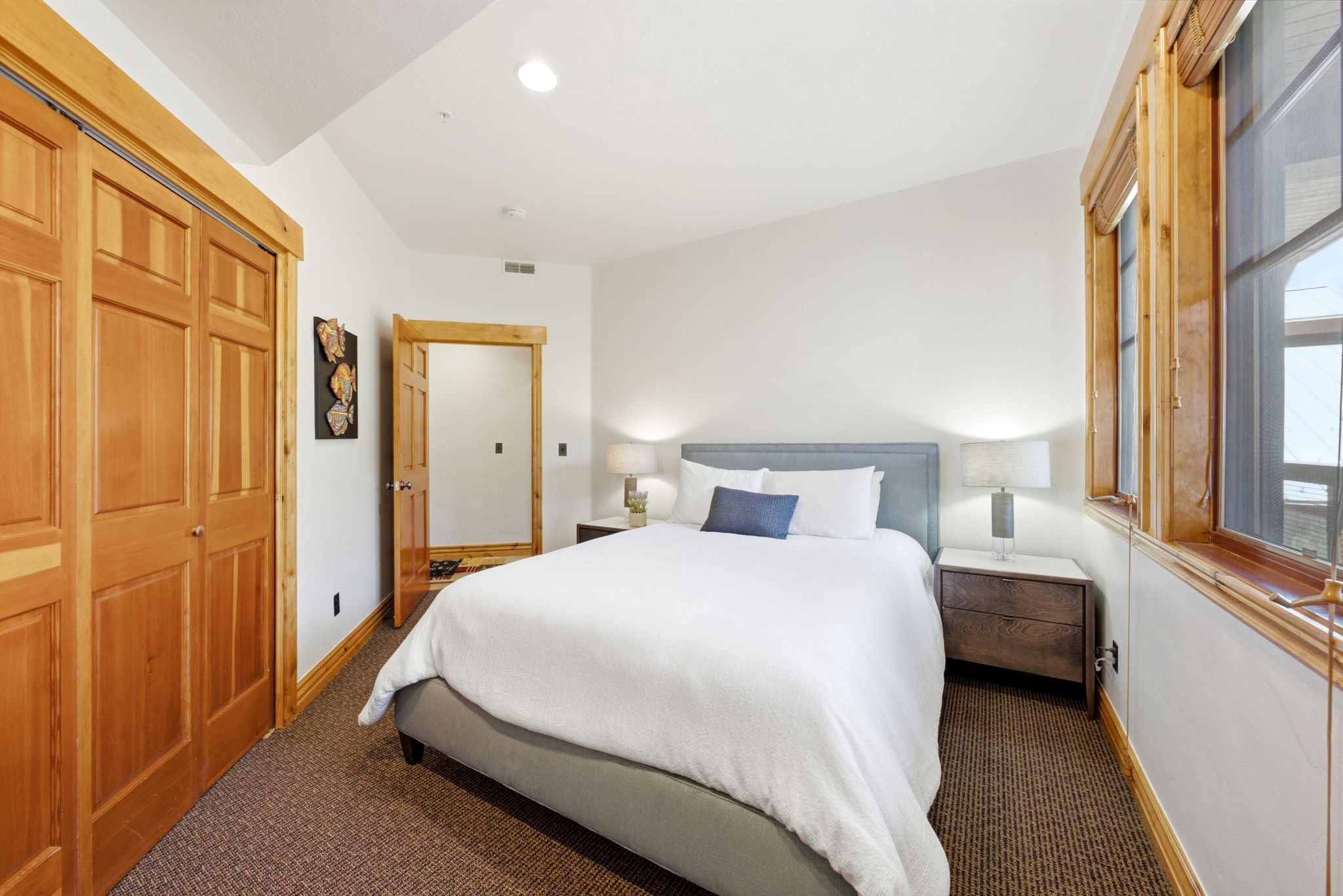 Vaulted ceiling bedroom with natural wood trim and doors