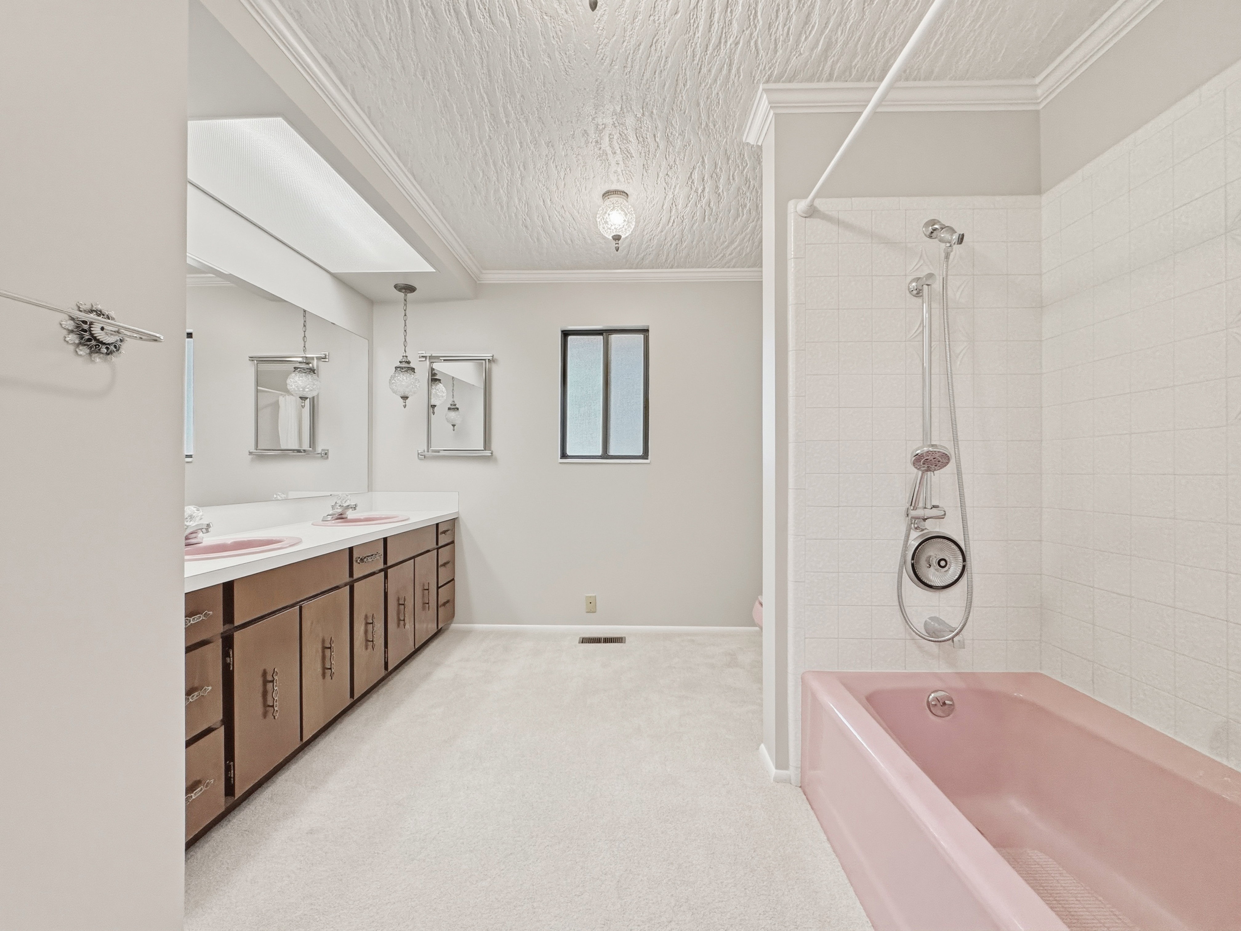 Bathroom featuring a dual vanity with a white countertop and wood-finish cabinetry