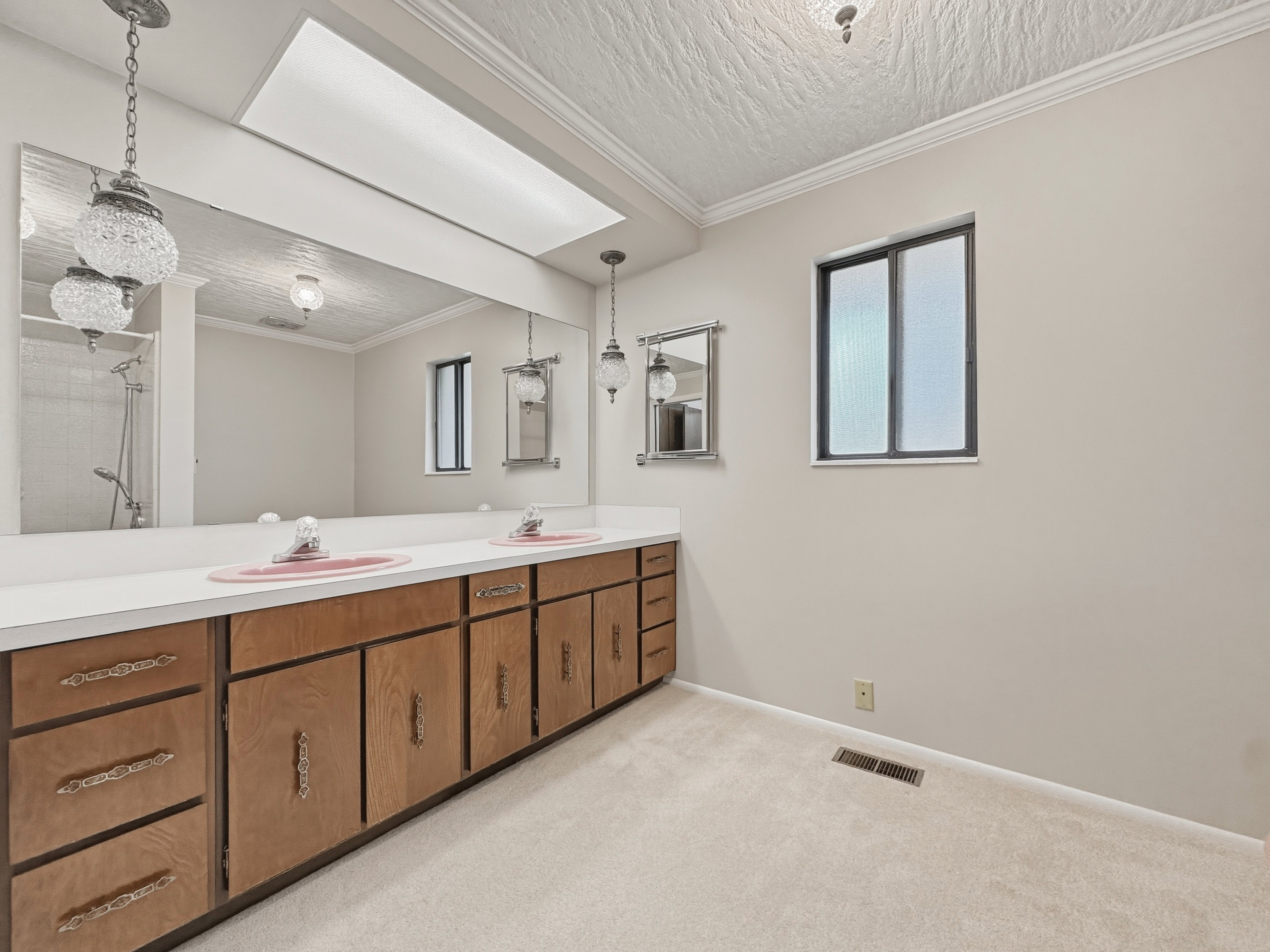 Dual vanity featuring wood-finish cabinetry and white countertops