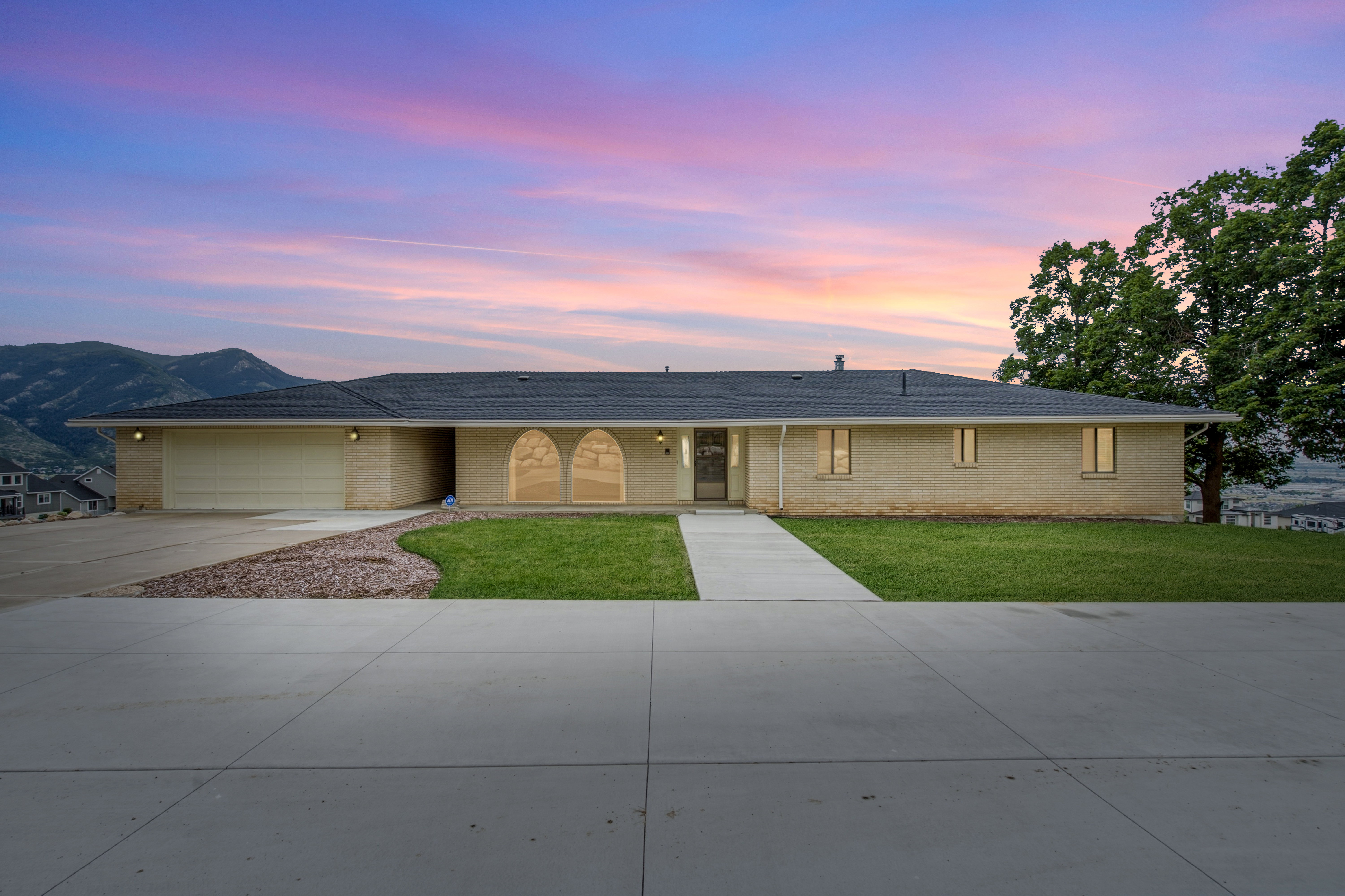 Ranch-style residence featuring a prominent front driveway and walkway