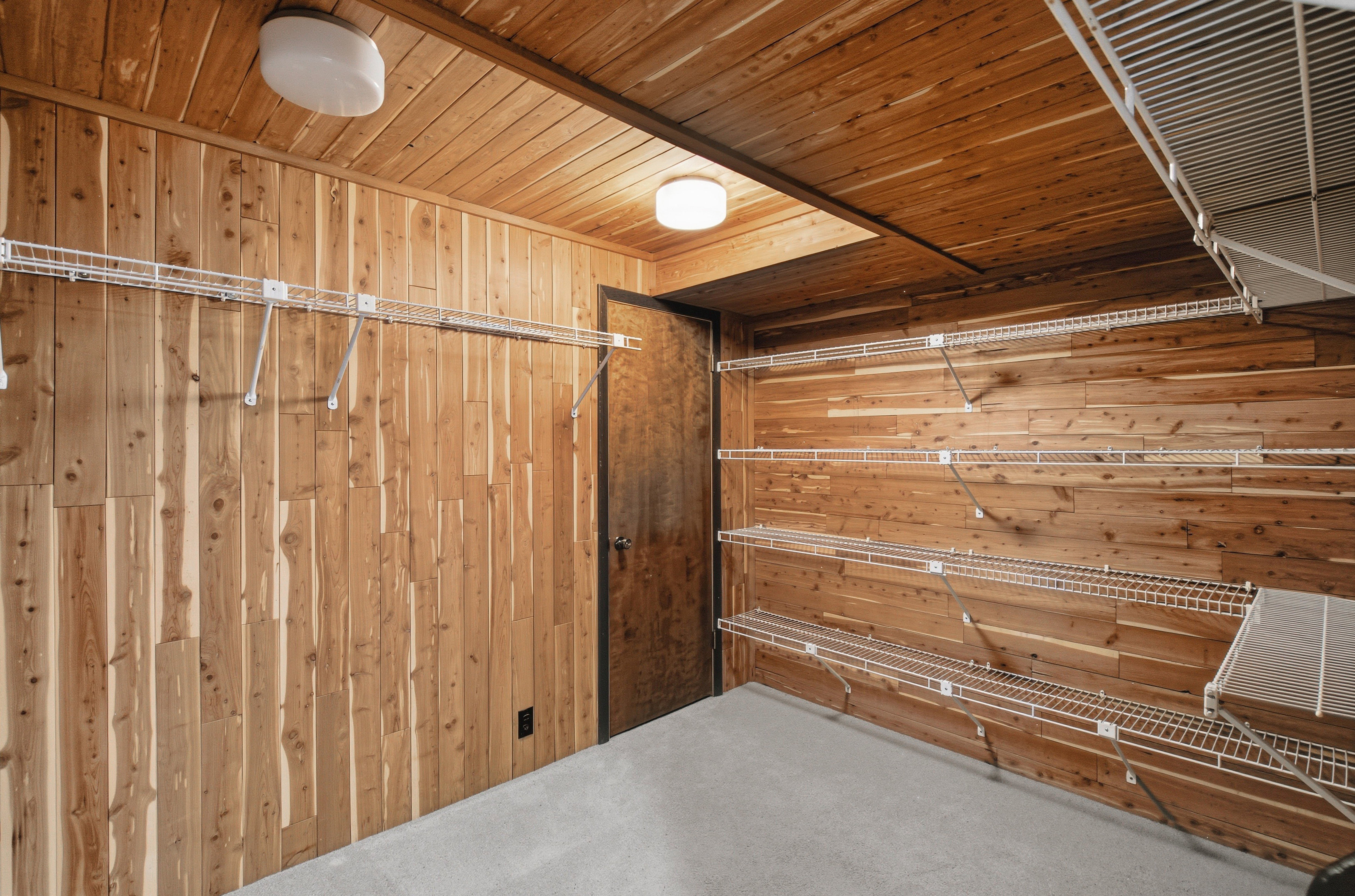 Cedar wood plank walls and ceiling with integrated flush-mount lighting