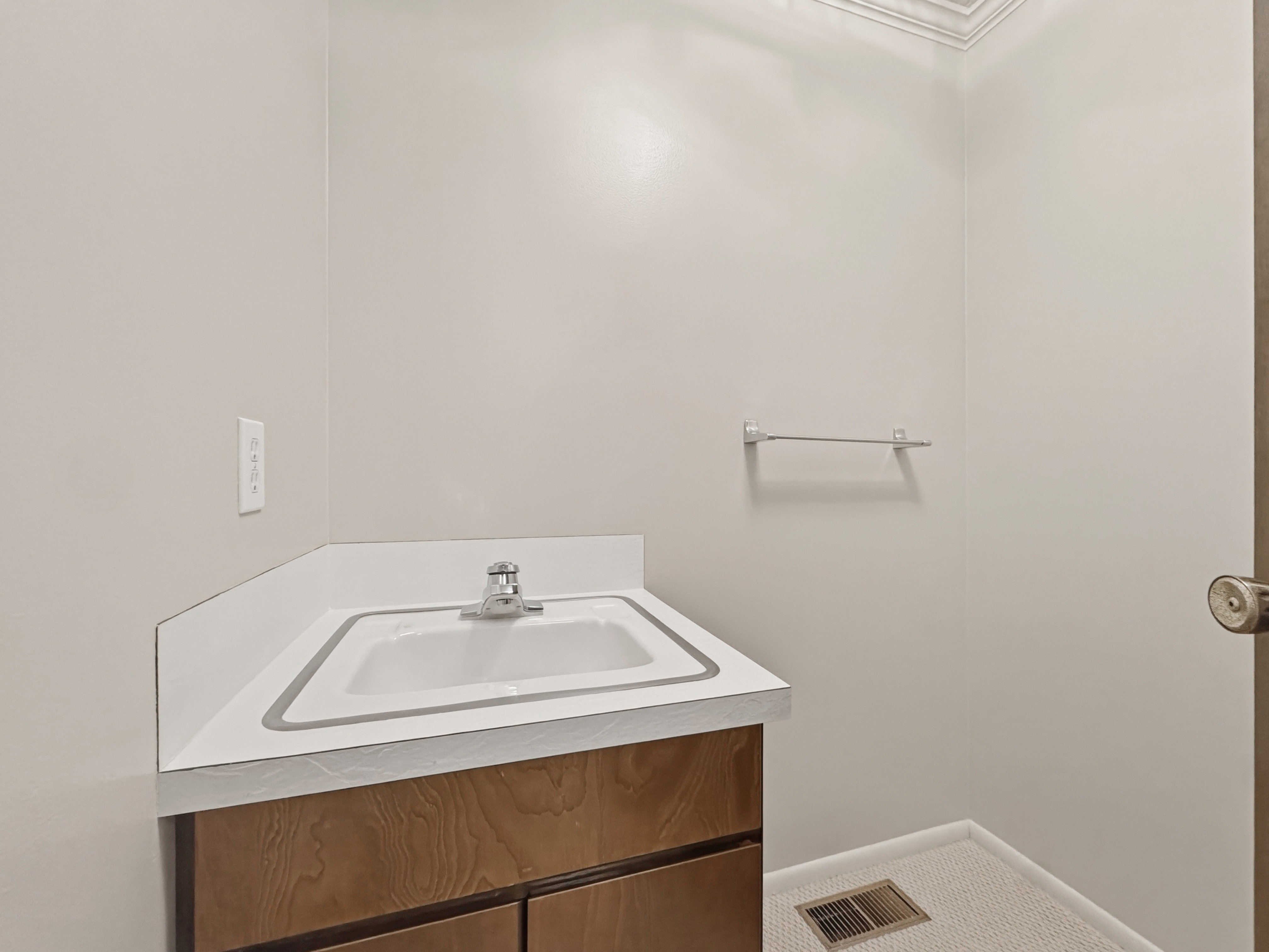 Vanity with wood-finish cabinetry and an integrated sink with a chrome faucet
