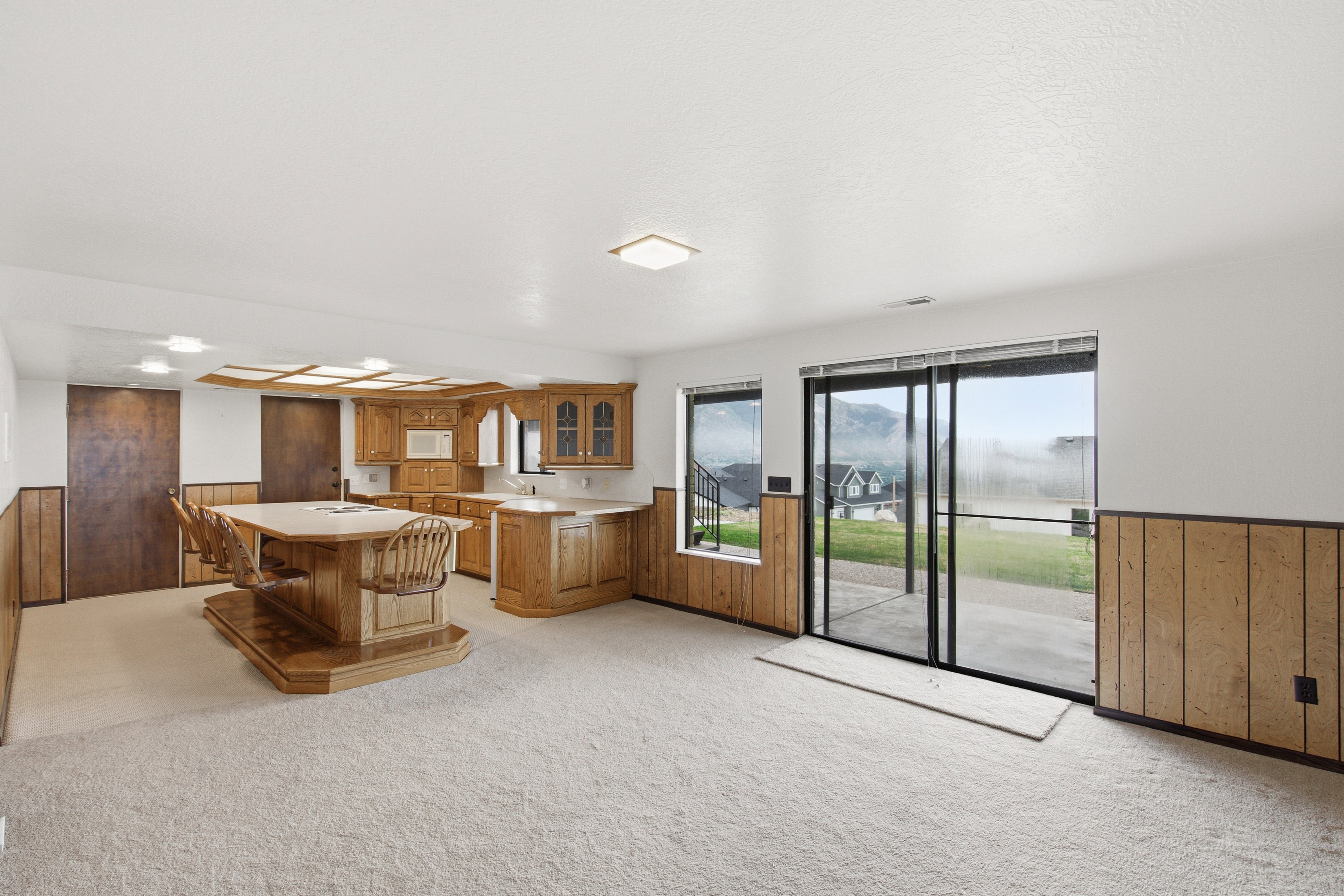 Lower-level entertainment space featuring a built-in wet bar with wood cabinetry and an integrated island with seating