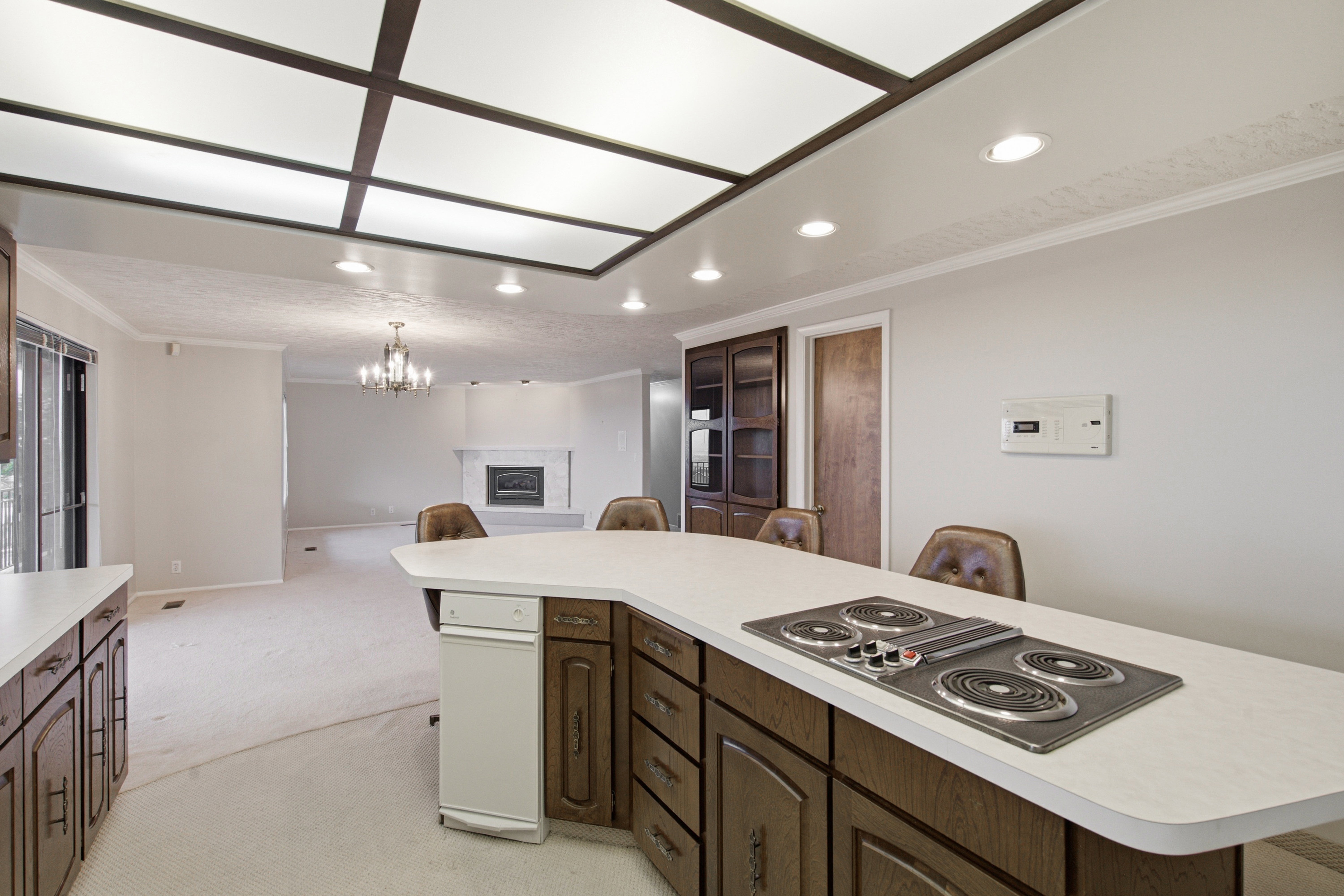 Kitchen island with a built-in cooktop, ample cabinetry, and countertop seating