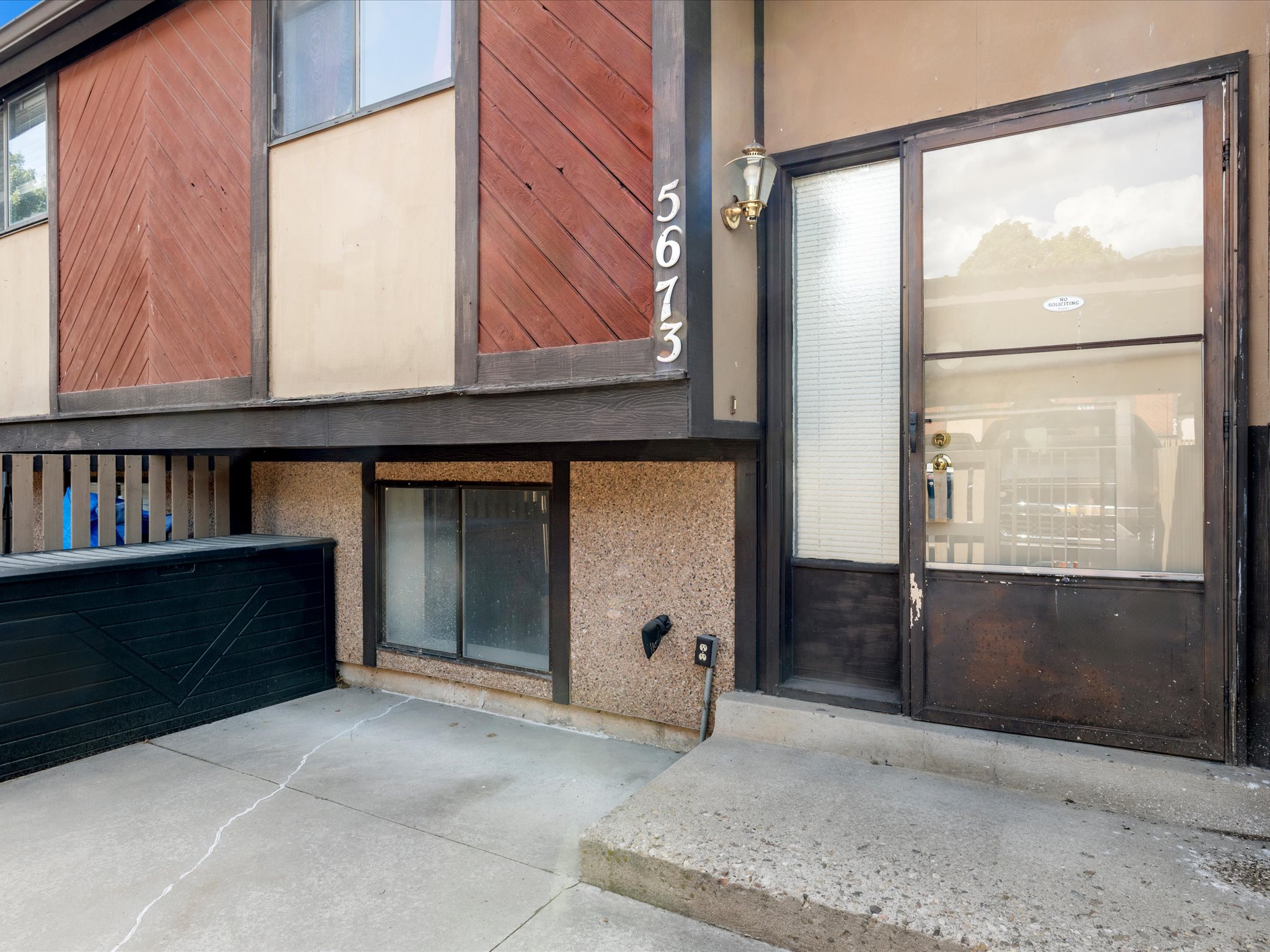 Multi-level exterior featuring concrete steps, an entry door with sidelight.