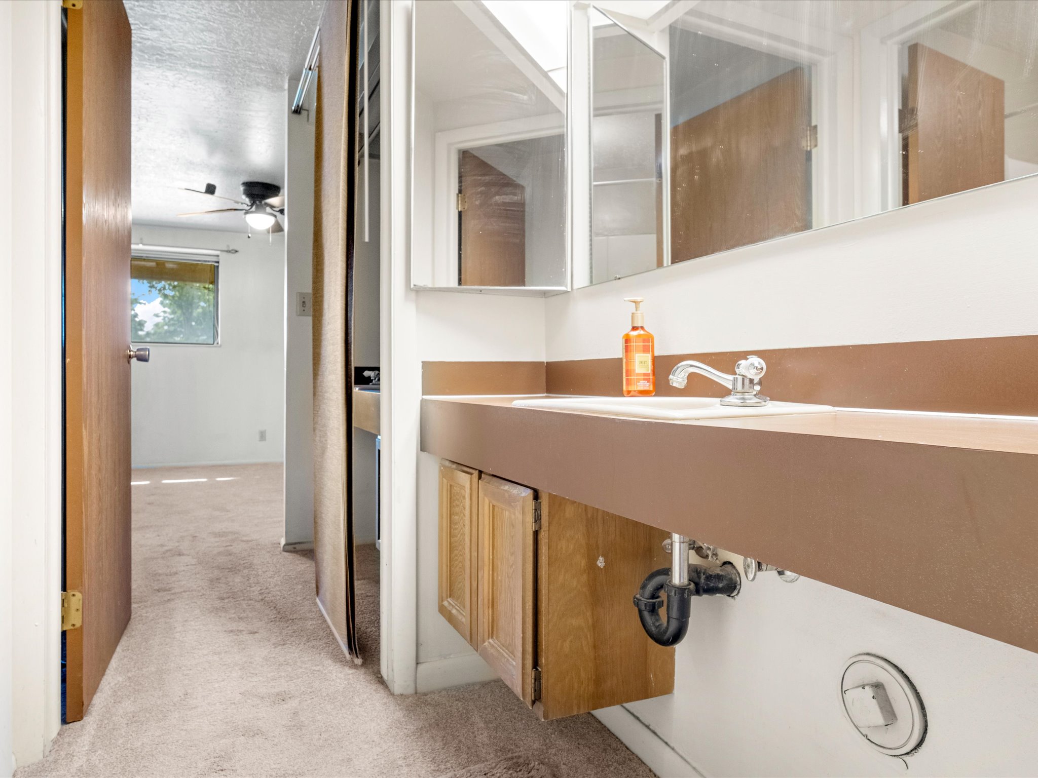 Vanity featuring an integrated sink and wood-finish cabinetry
