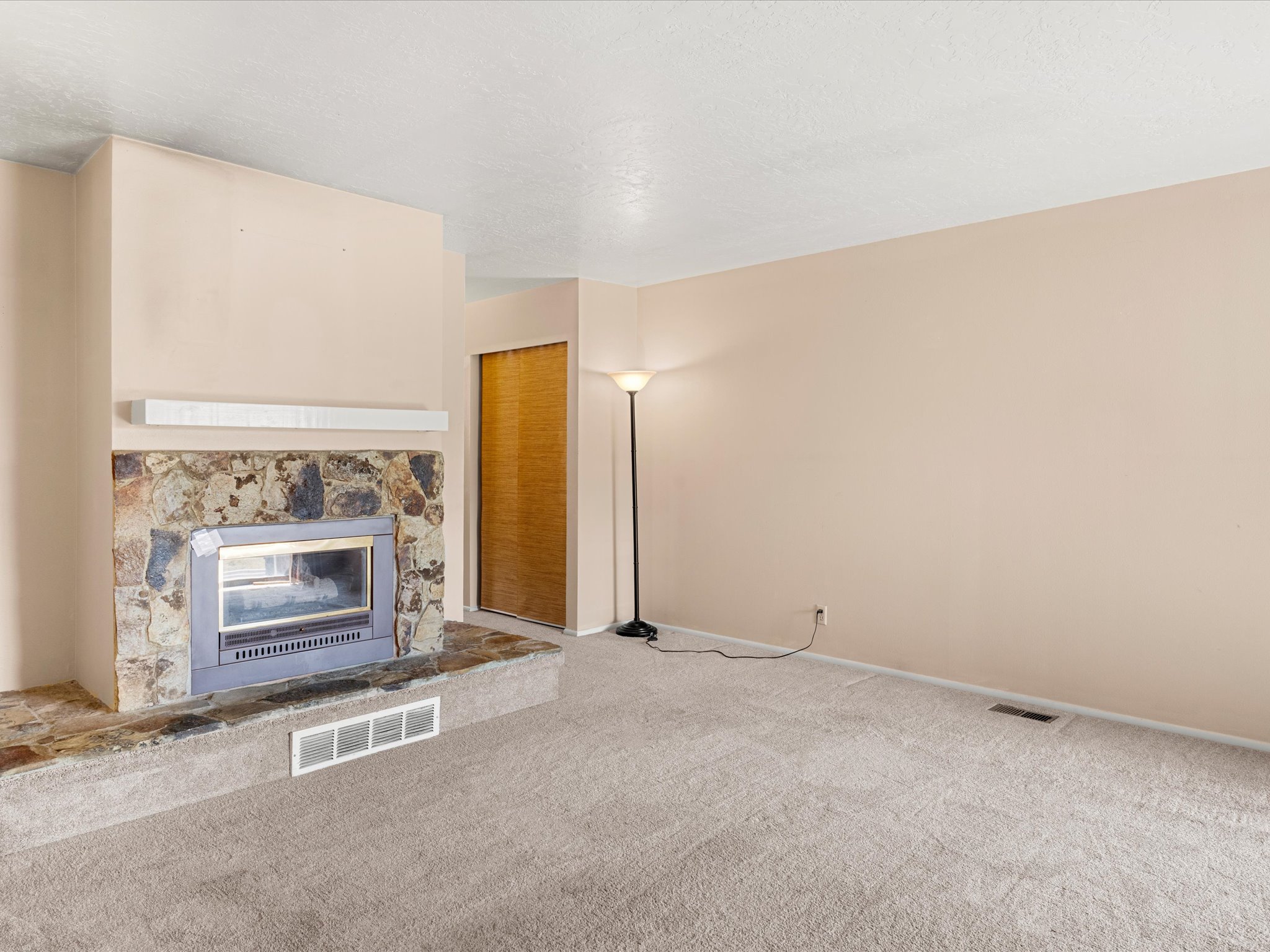 Stone-faced fireplace with a raised hearth and built-in insert