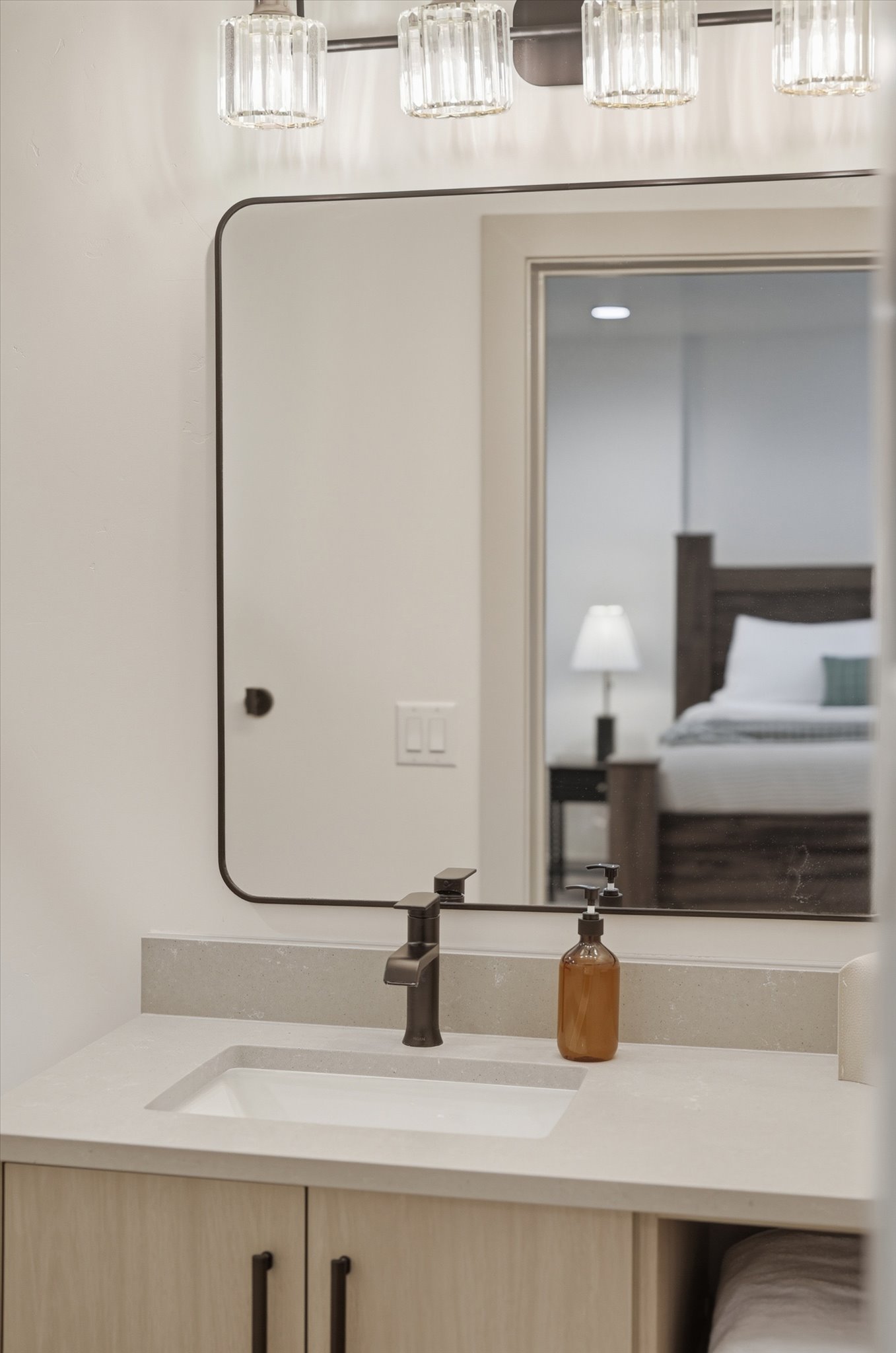 Bathroom vanity featuring a light-toned countertop with an integrated rectangular sink