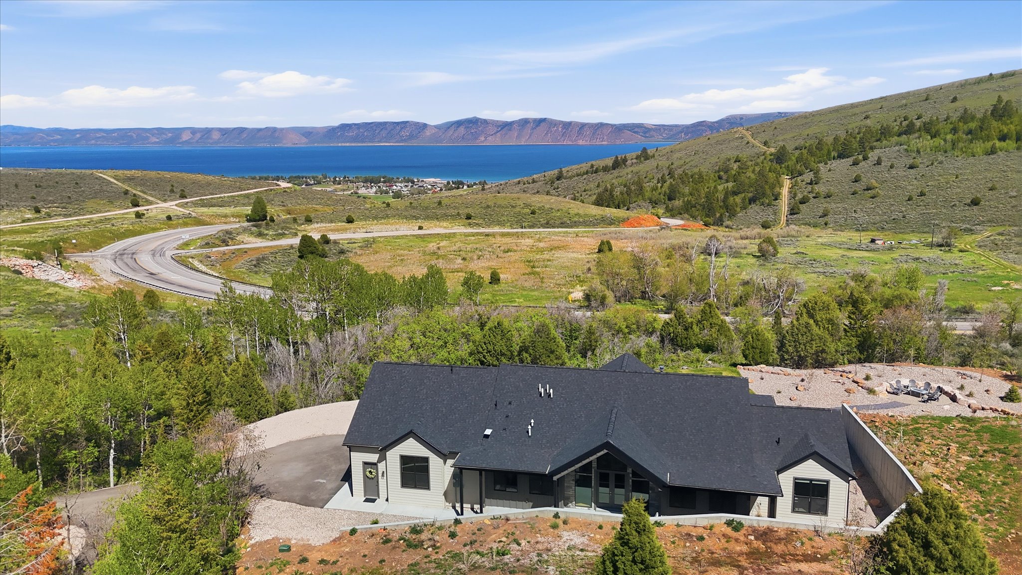 Modern single-story residence featuring a dark gray shingle roof and light gray siding