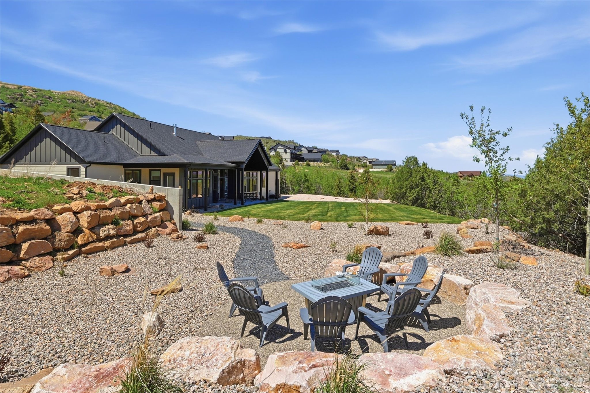 Outdoor living space featuring a gravel fire pit area with natural rock accents