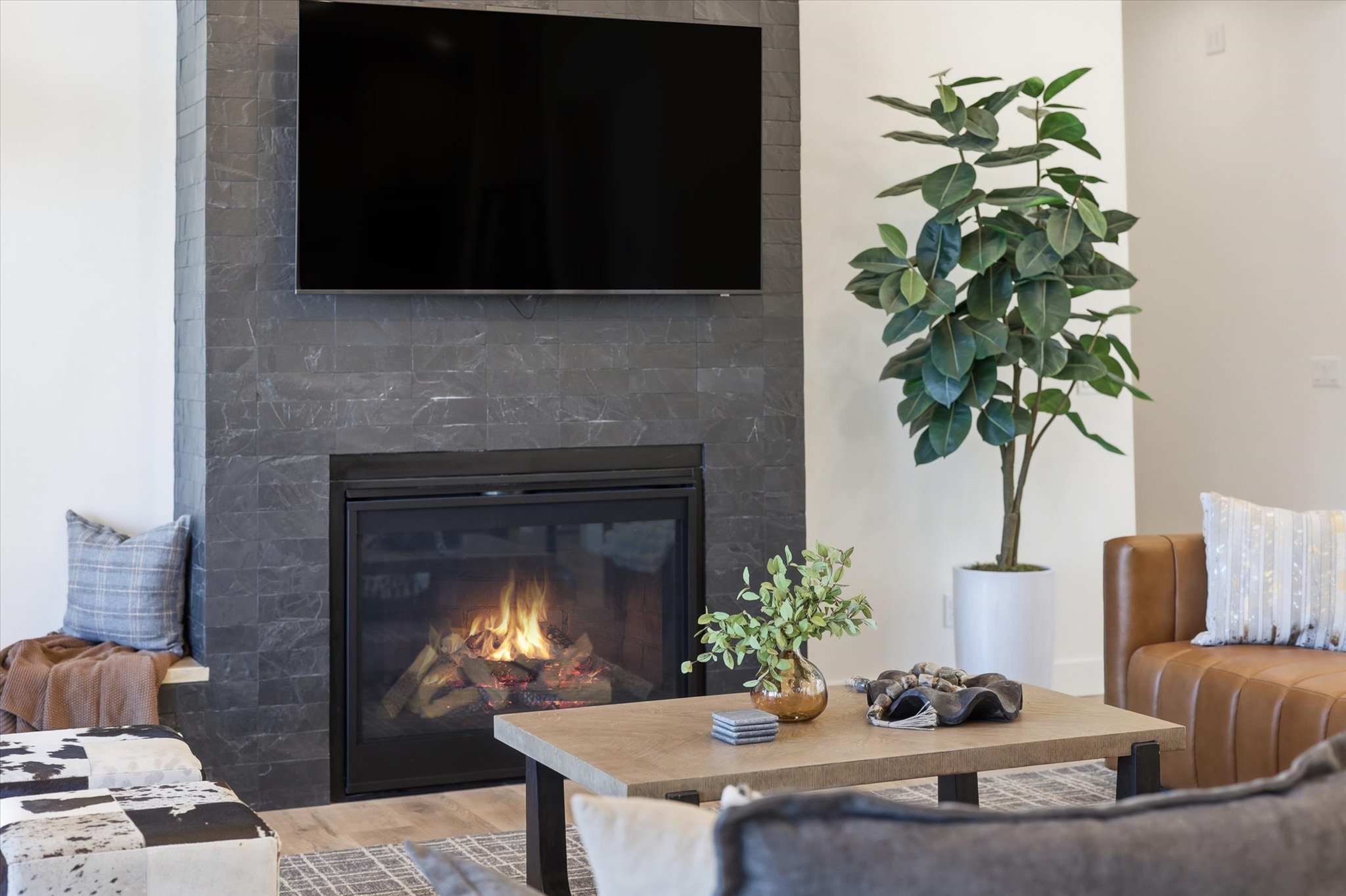 Modern fireplace featuring dark stacked stone surround and a built-in hearth