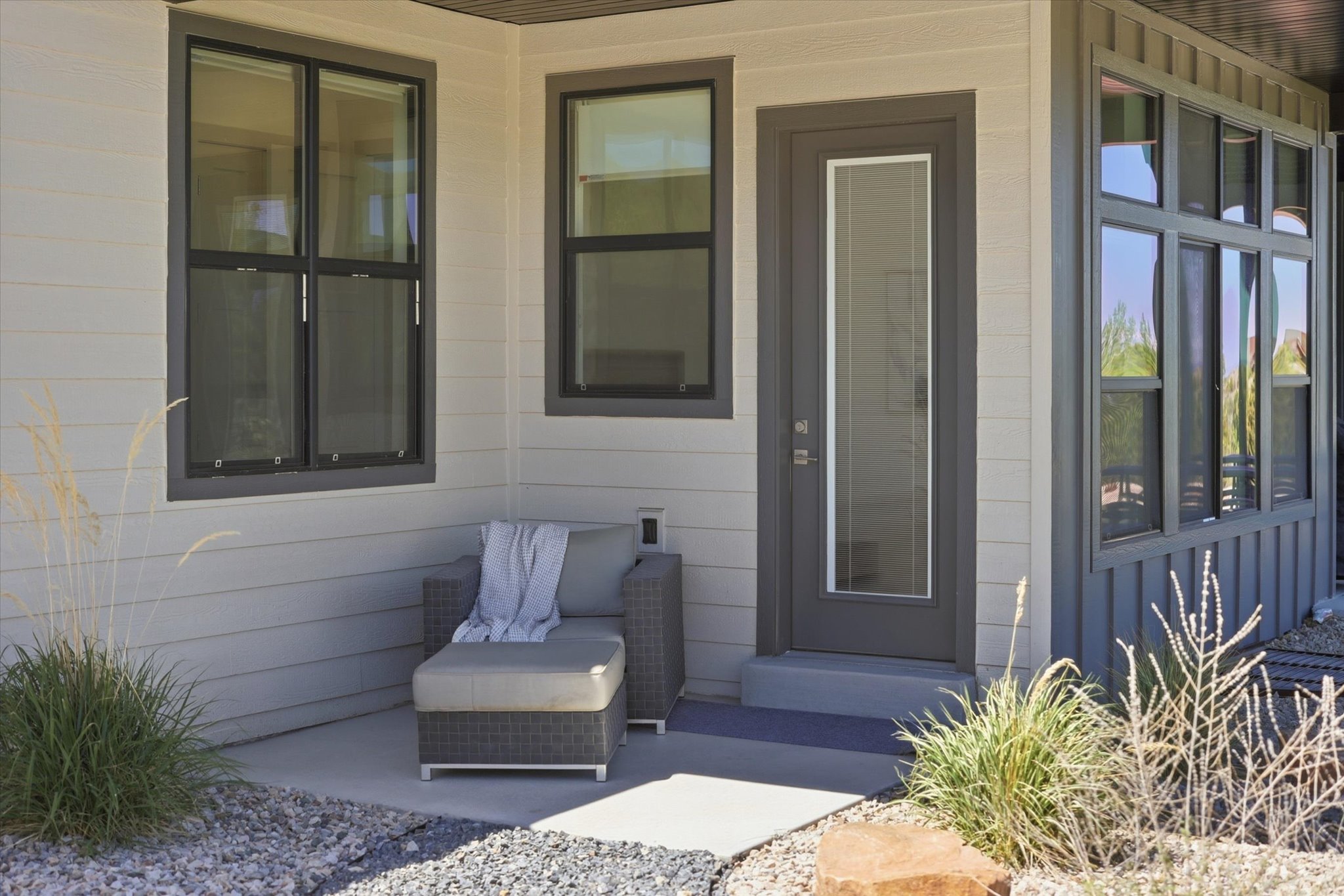 Contemporary exterior featuring light-colored horizontal siding and dark trim
