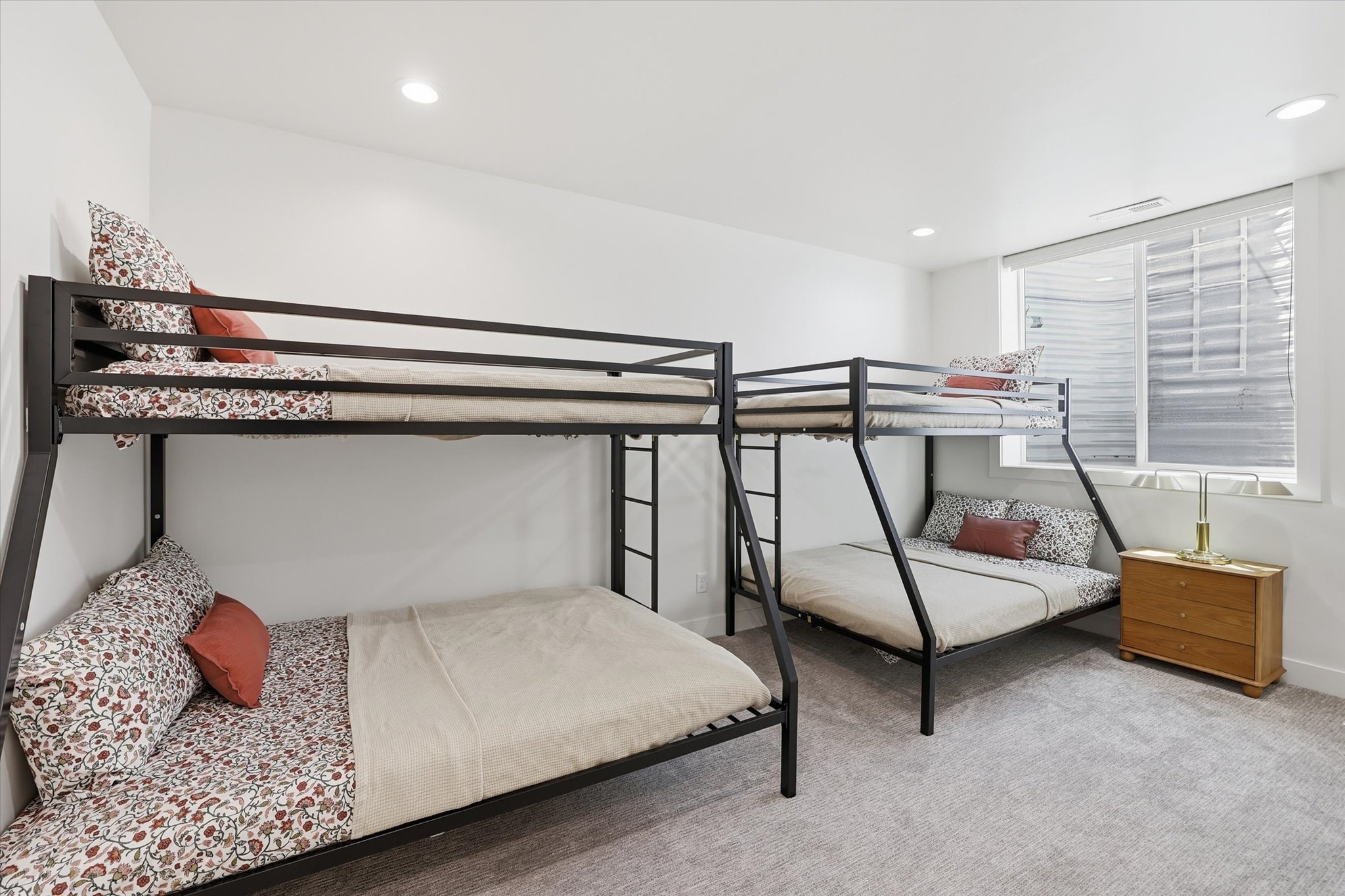 Spacious room featuring light gray carpeting and a large window with privacy blinds