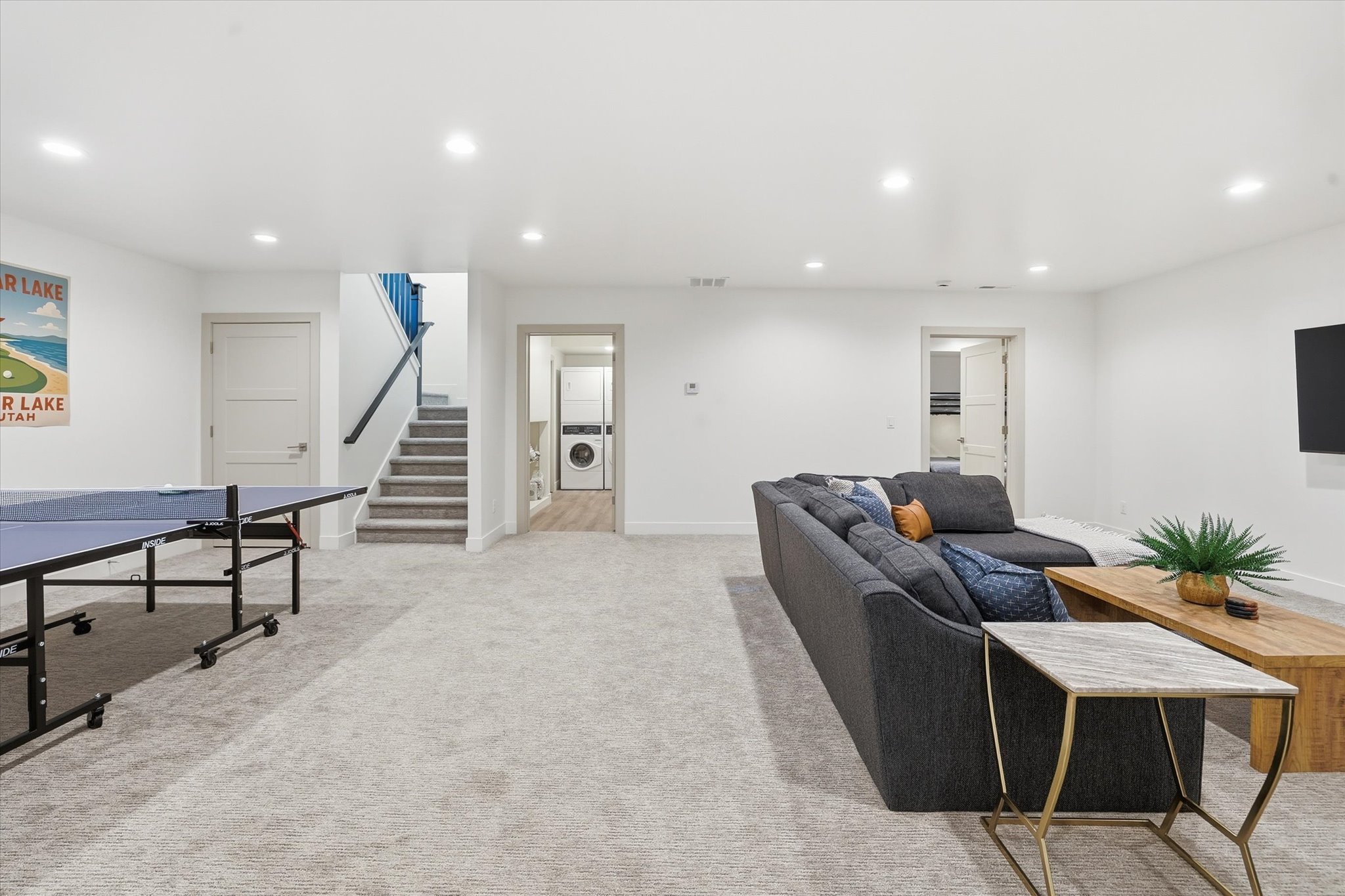 Spacious finished basement featuring light gray carpeting, recessed lighting, and white walls