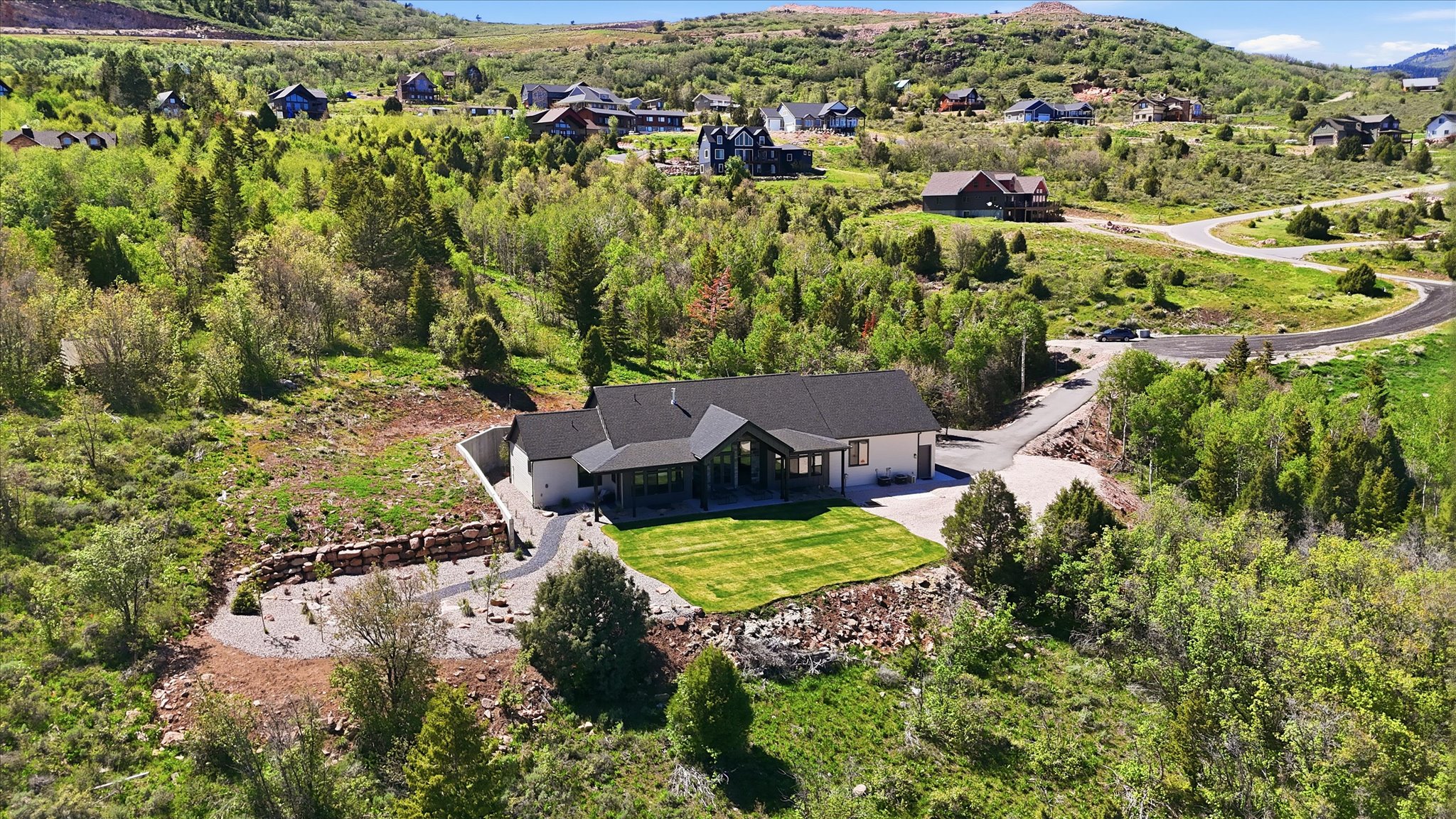 Contemporary single-story residence featuring a dark gray roofline and light-toned siding