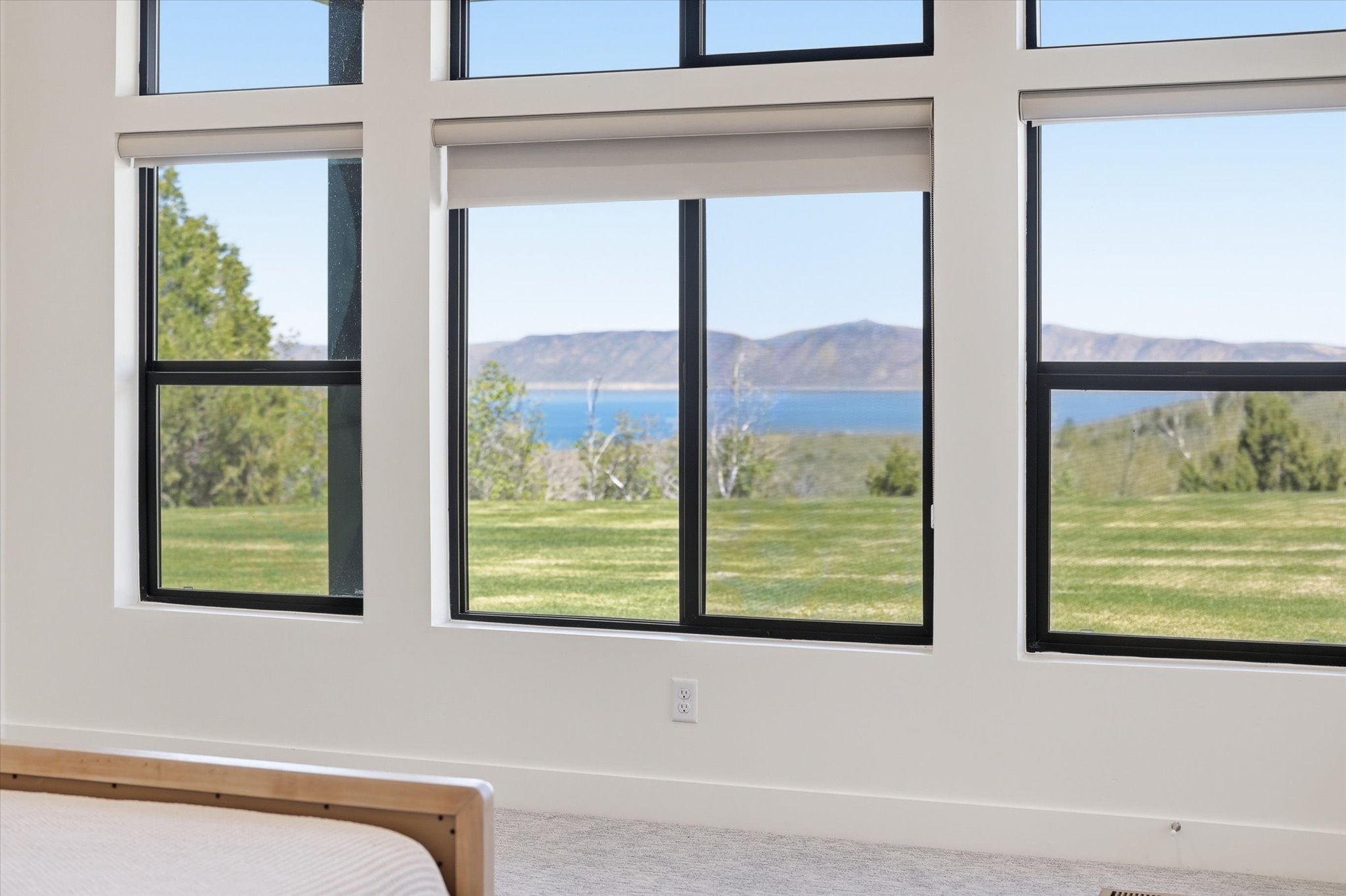 Floor-to-ceiling windows with black frames, offering expansive outdoor scenery