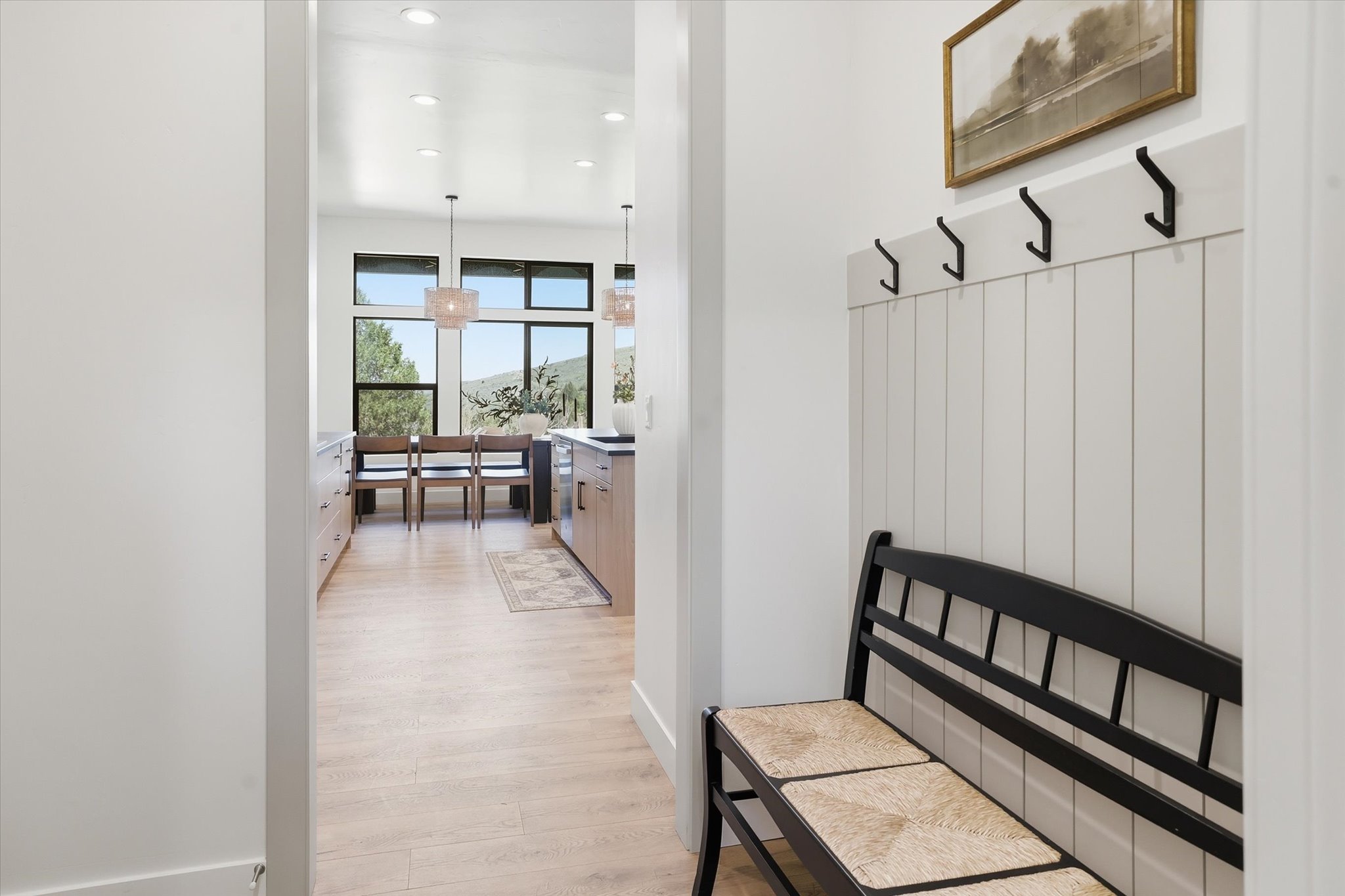 Entryway featuring a white board-and-batten accent wall with black hooks