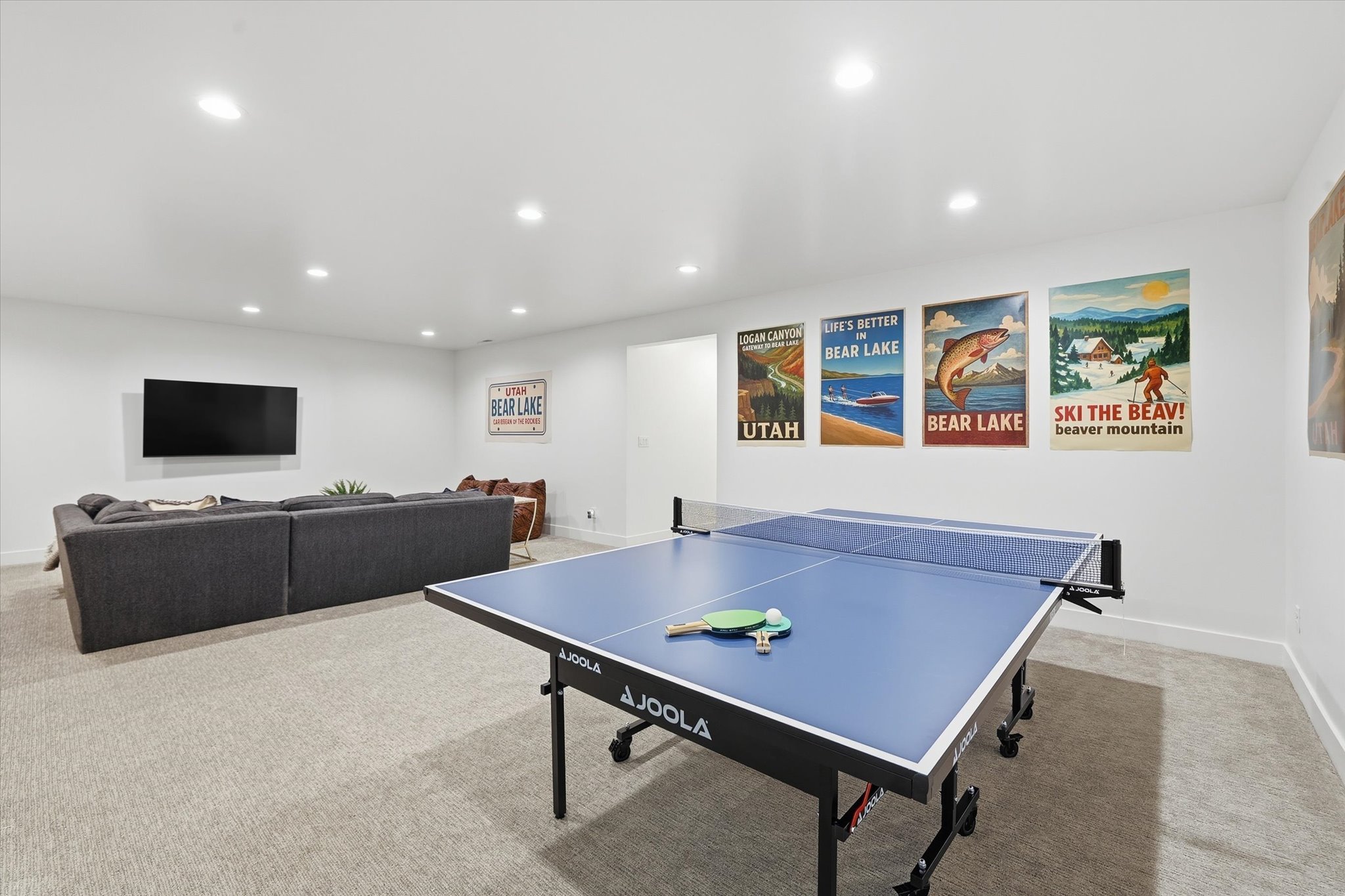 Spacious recreational room featuring recessed lighting, light-toned carpeting, and white baseboards