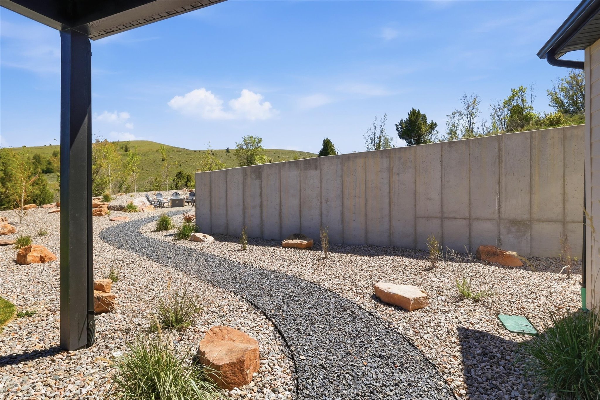 Landscaped outdoor area featuring a winding gravel path, assorted decorative rocks, and a low-maintenance gravel ground cover