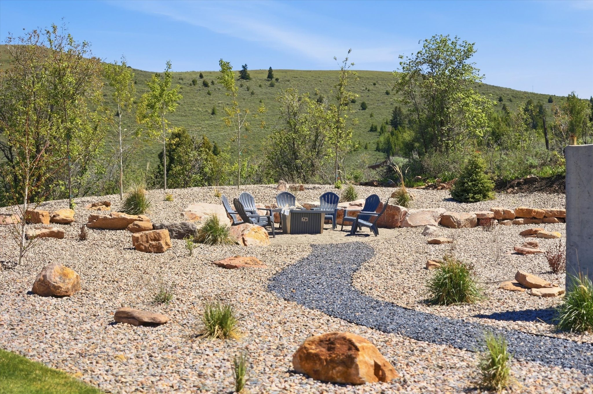 Landscaped outdoor area featuring a gravel ground cover and a winding dark gravel path