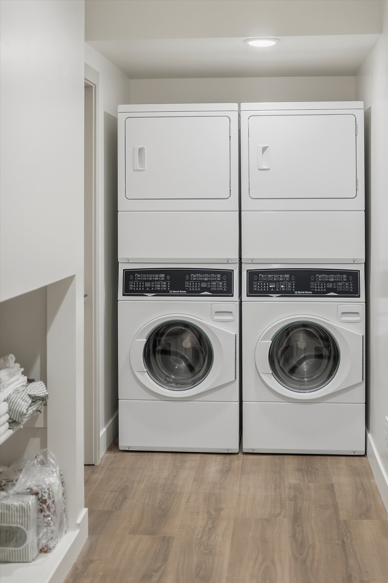 Dedicated laundry area featuring two stacked washer and dryer units