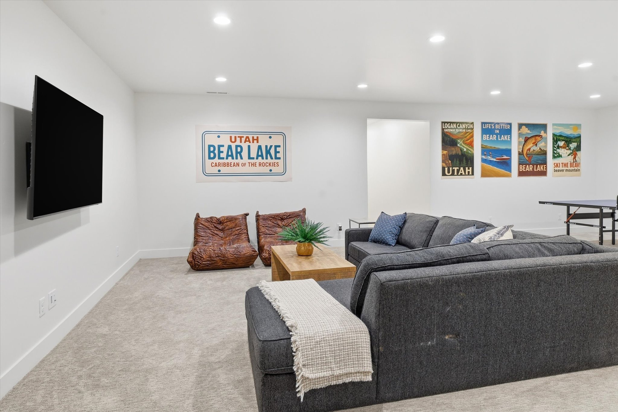 Spacious recreational area featuring recessed lighting, light-toned carpeting, and a wall-mounted flat panel display