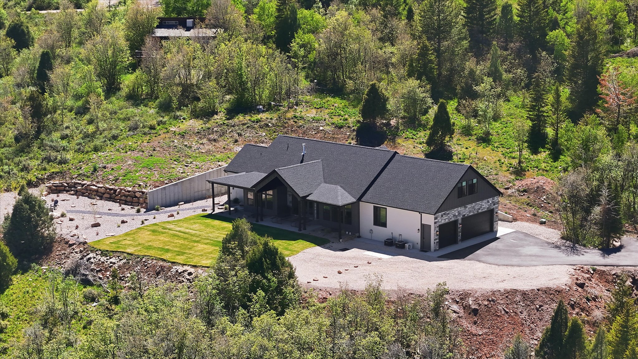 Contemporary home featuring a dark shingle roof and a covered front porch