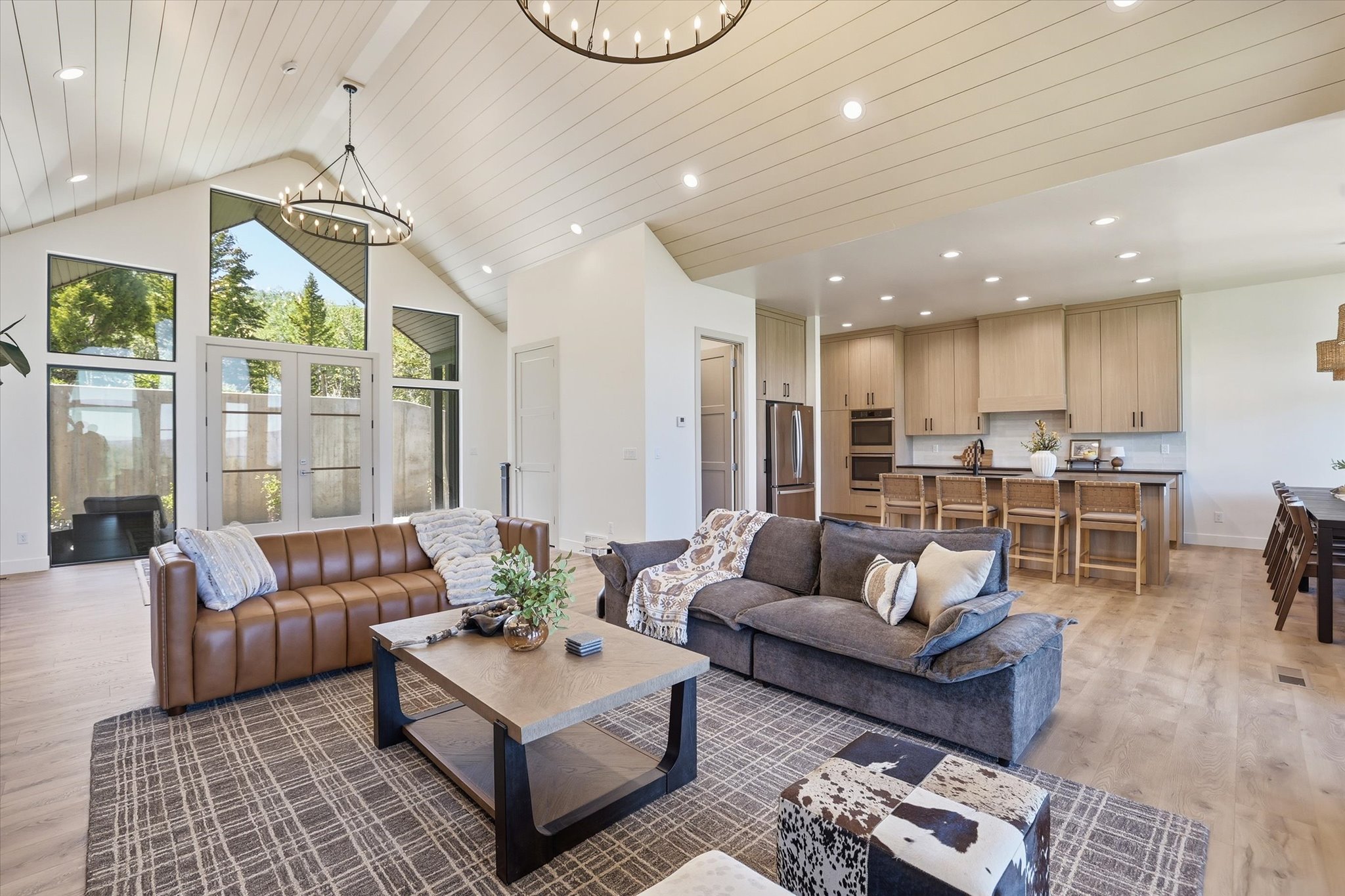 Open-concept living space featuring vaulted ceilings with wood-finish planks and recessed lighting