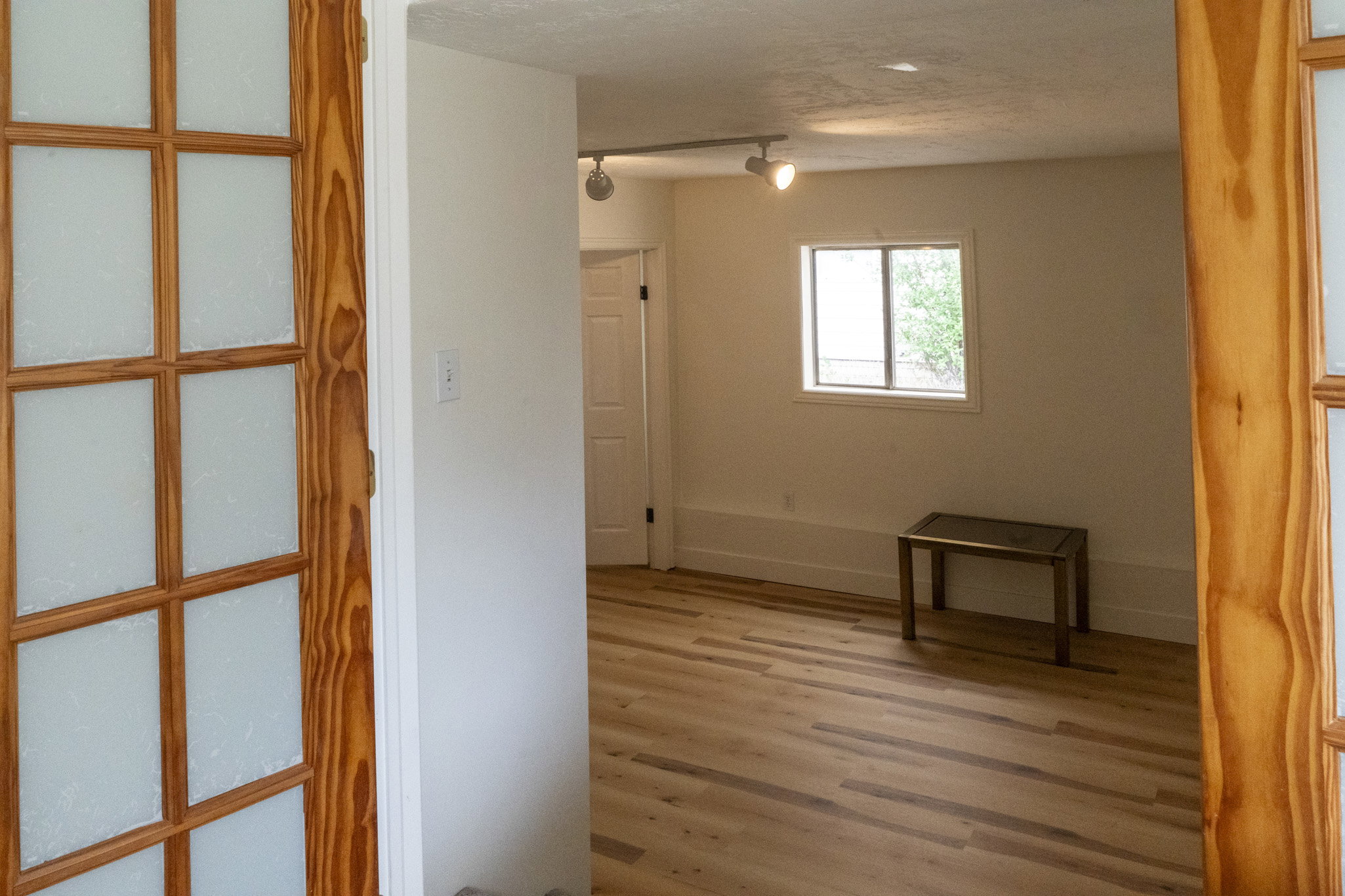 Room featuring light wood-finish flooring, white walls, and a window with exterior views