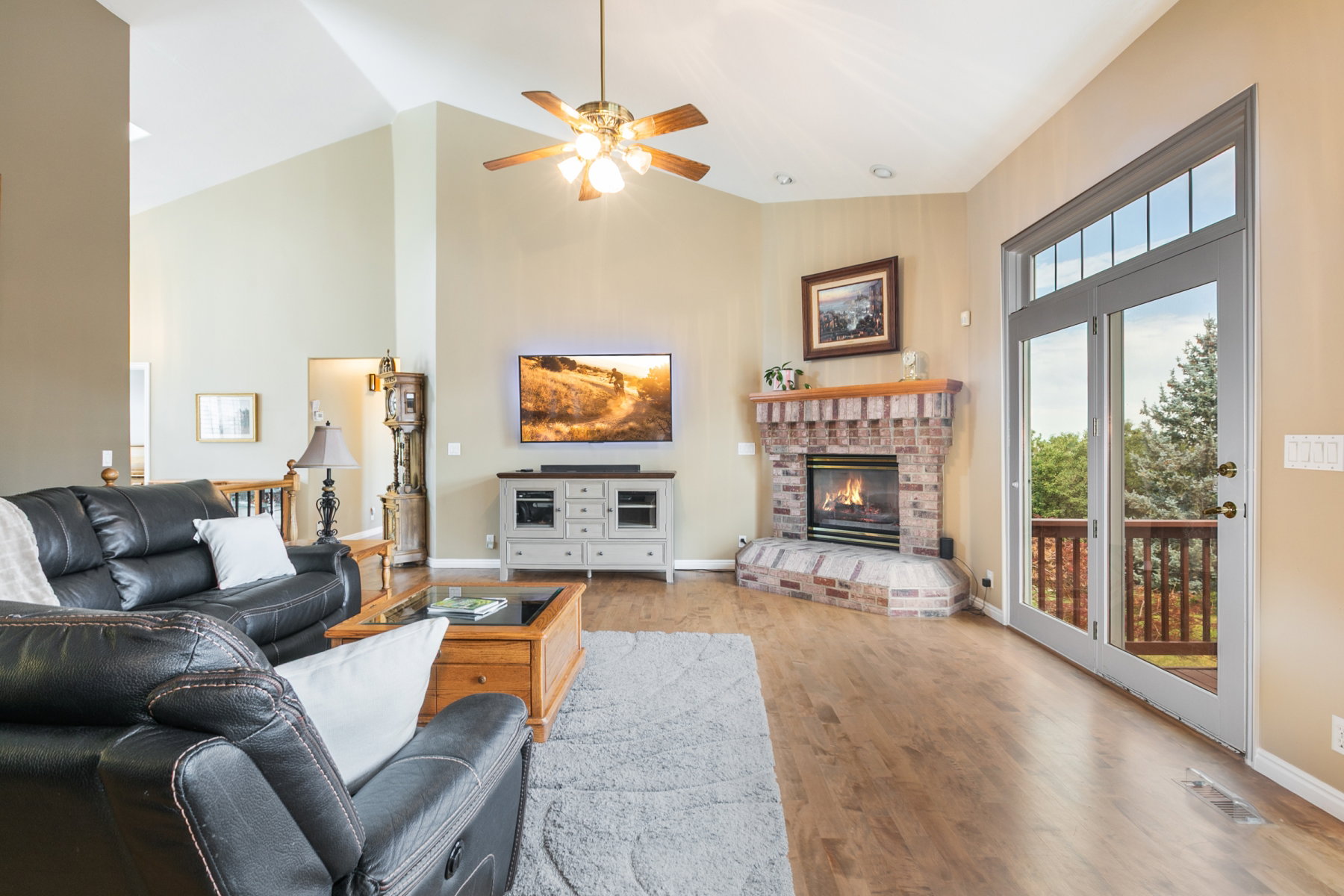 Spacious living area featuring vaulted ceilings and wood-finish flooring